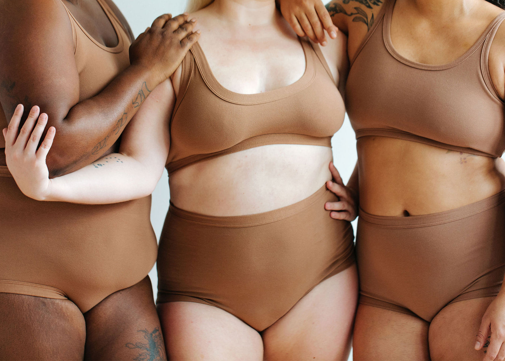 Close up of three models wearing various items in Thunderpants Hazelnut color.