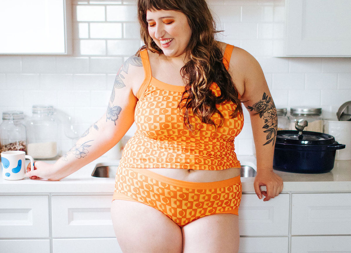 Model standing in a kitchen wearing Autumn Equinox print in Thunderpants Hipster style underwear and Camisole.