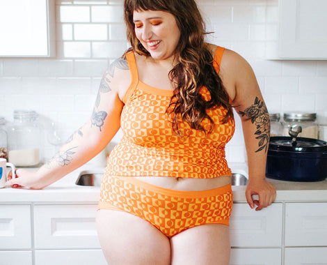 Model standing in a kitchen wearing Autumn Equinox print in Thunderpants Hipster style underwear and Camisole.