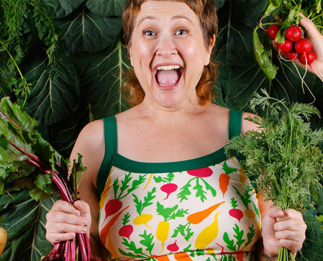 Model smiling really big surrounded by vegetables wearing Thunderpants Camisole in the Root Veggies print. 