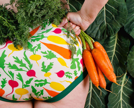 Close up of models bum wearing Thunderpants Original style underwear in Root Veggies print: pink, yellow, orange, and green.