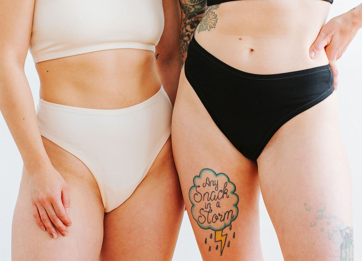 Close up of two models wearing Thunderpants Thong style underwear in Plain Vanilla and Plain Black.