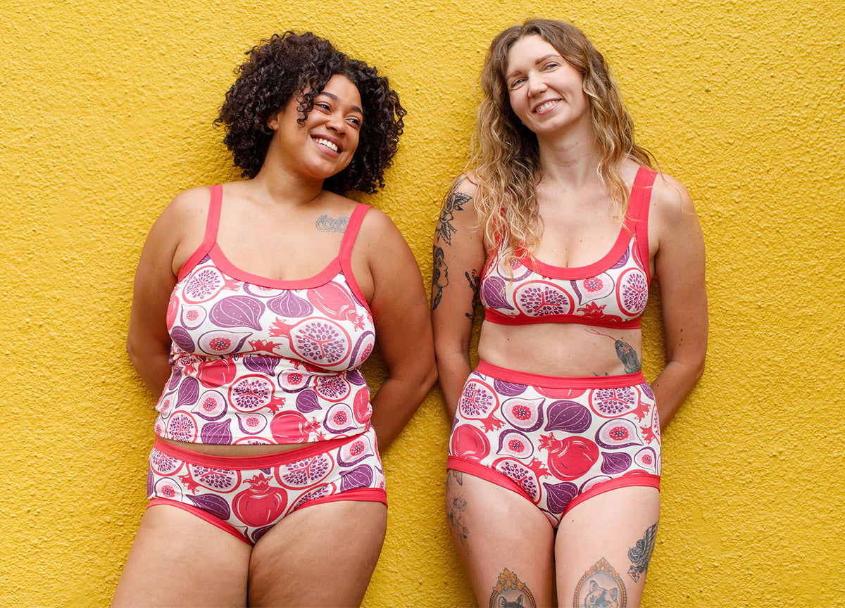 Two models wearing various Thunderpants items in Two Fruits - pomegranates and figs.