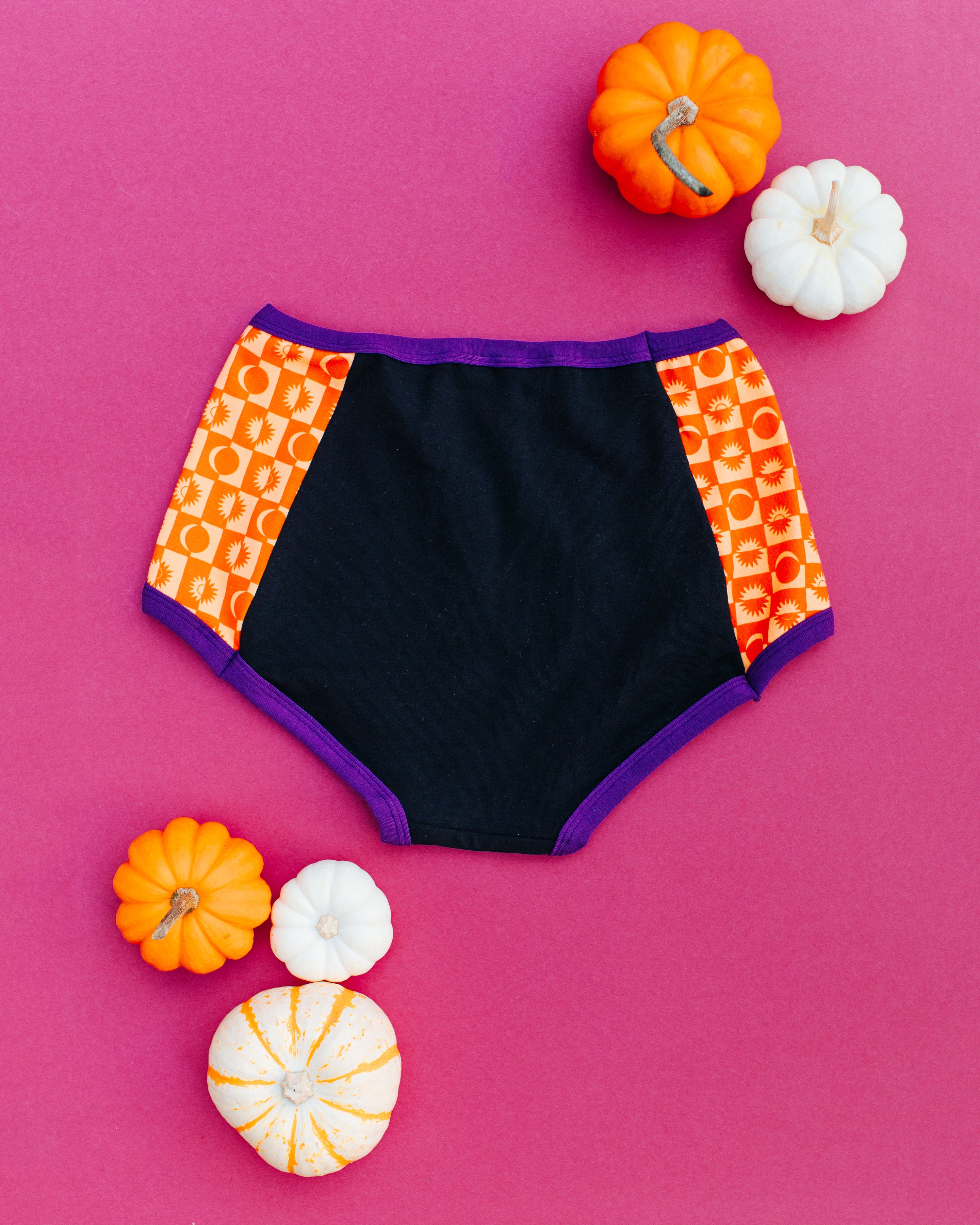Flat lay of the back of Thunderpants Original Panel Pants style underwear in Witch's Brew: Black with orange Autumn Equinox.