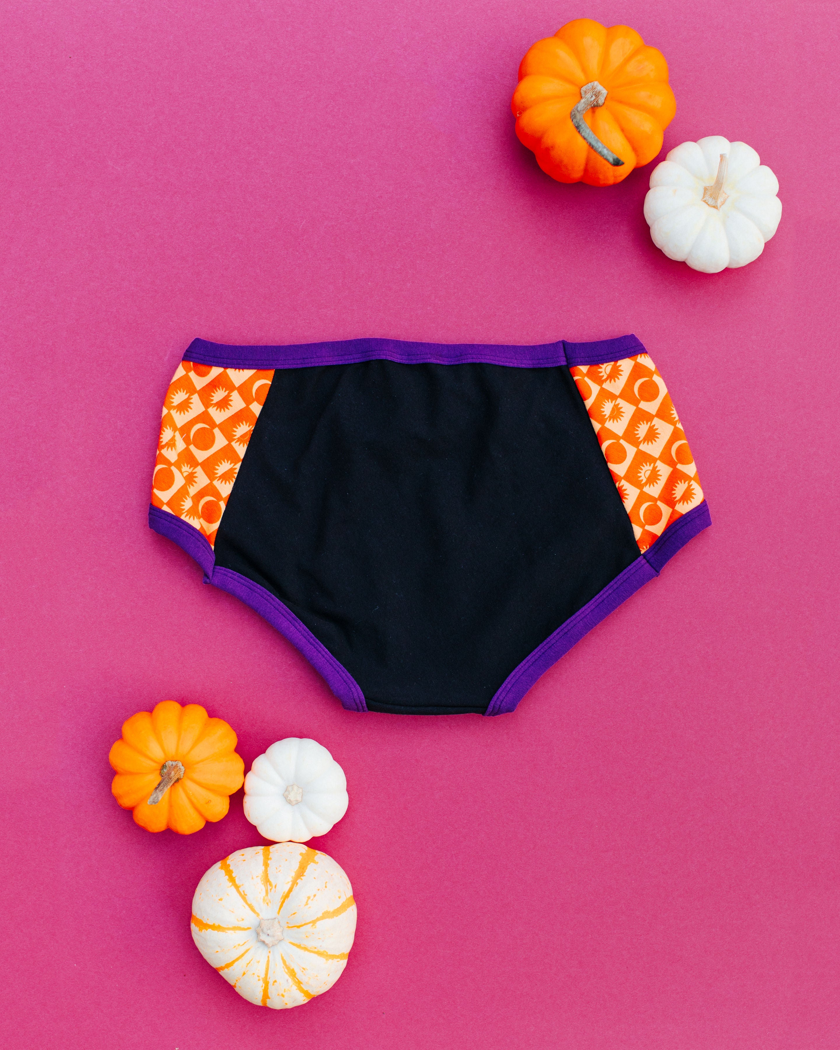 Flatlay of the back of Thunderpants Hipster Panel Pants style underwear in Witch's Brew: Black with orange Autumn Equinox.