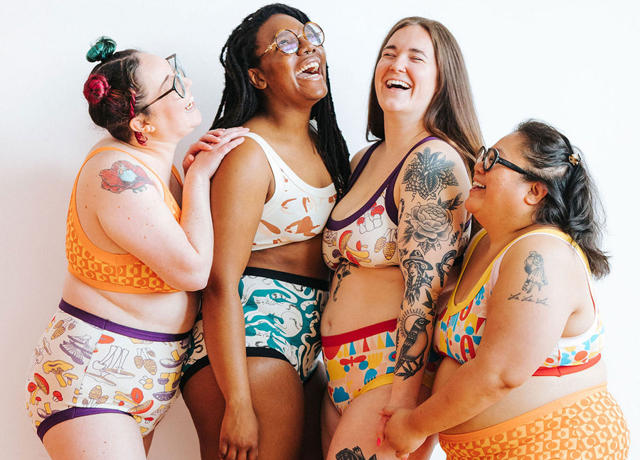 Four models laughing together wearing a variety of prints and styles.