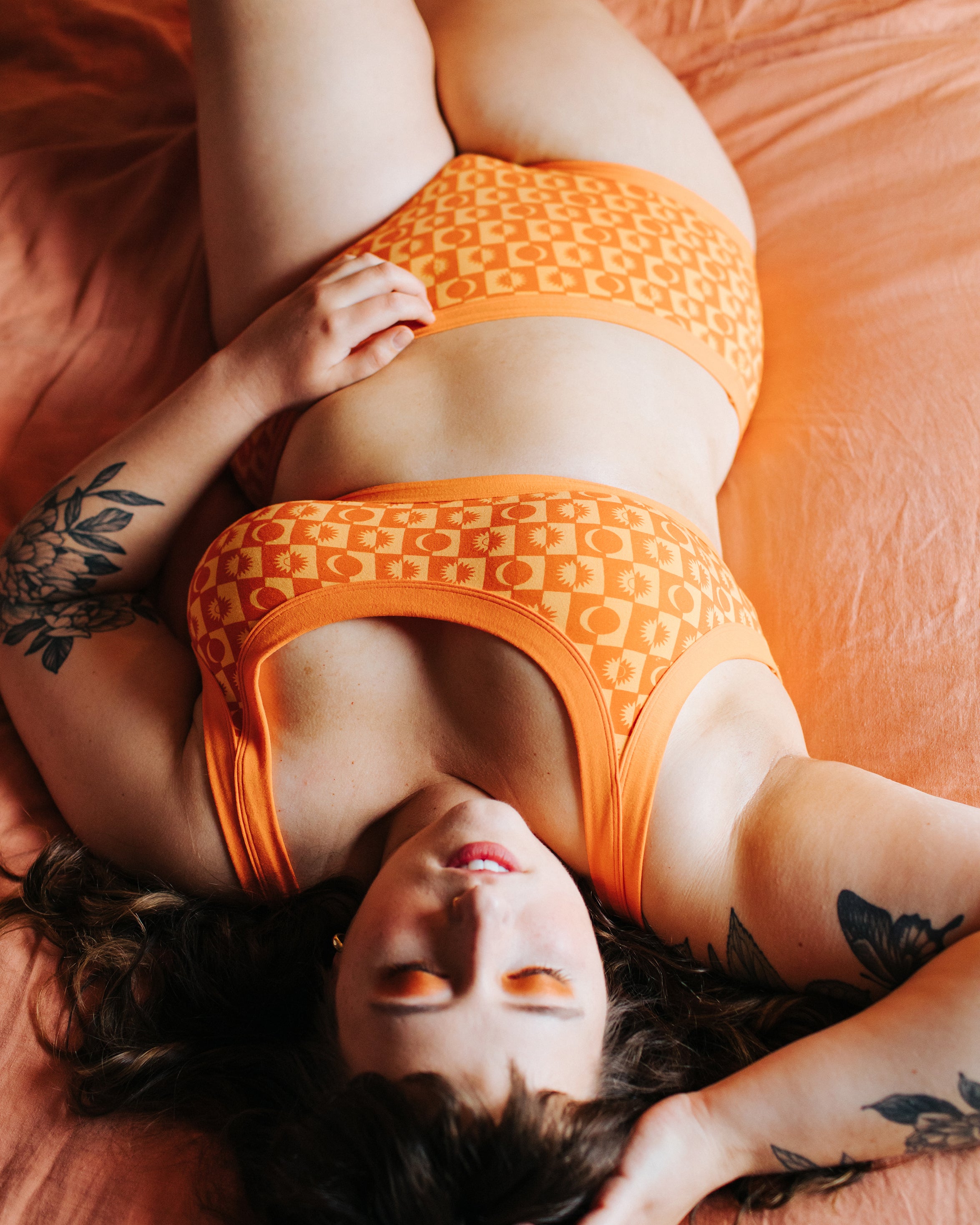 Model laying down wearing Thunderpants Original style underwear in Autumn Equinox print.