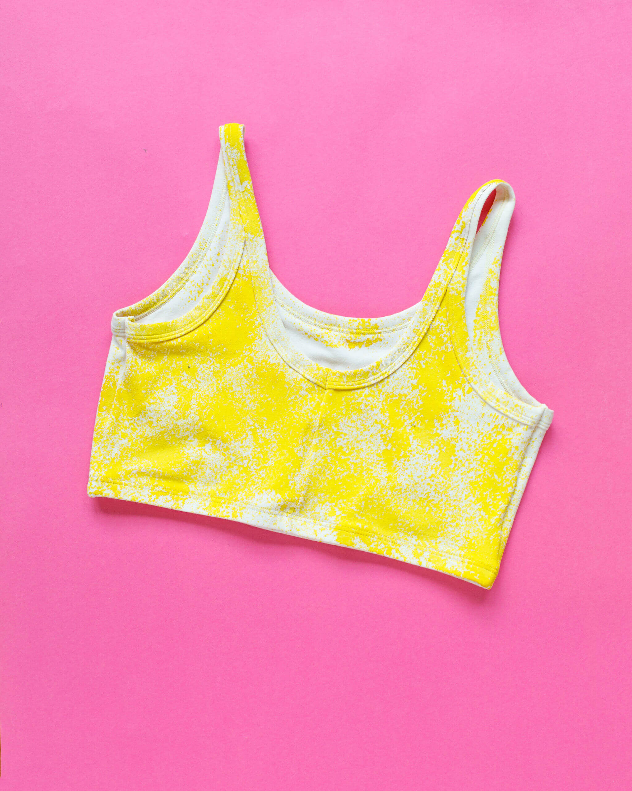 Flat lay of Thunderpants Longline Bra in Banana Pitch - yellow with one black banana print.