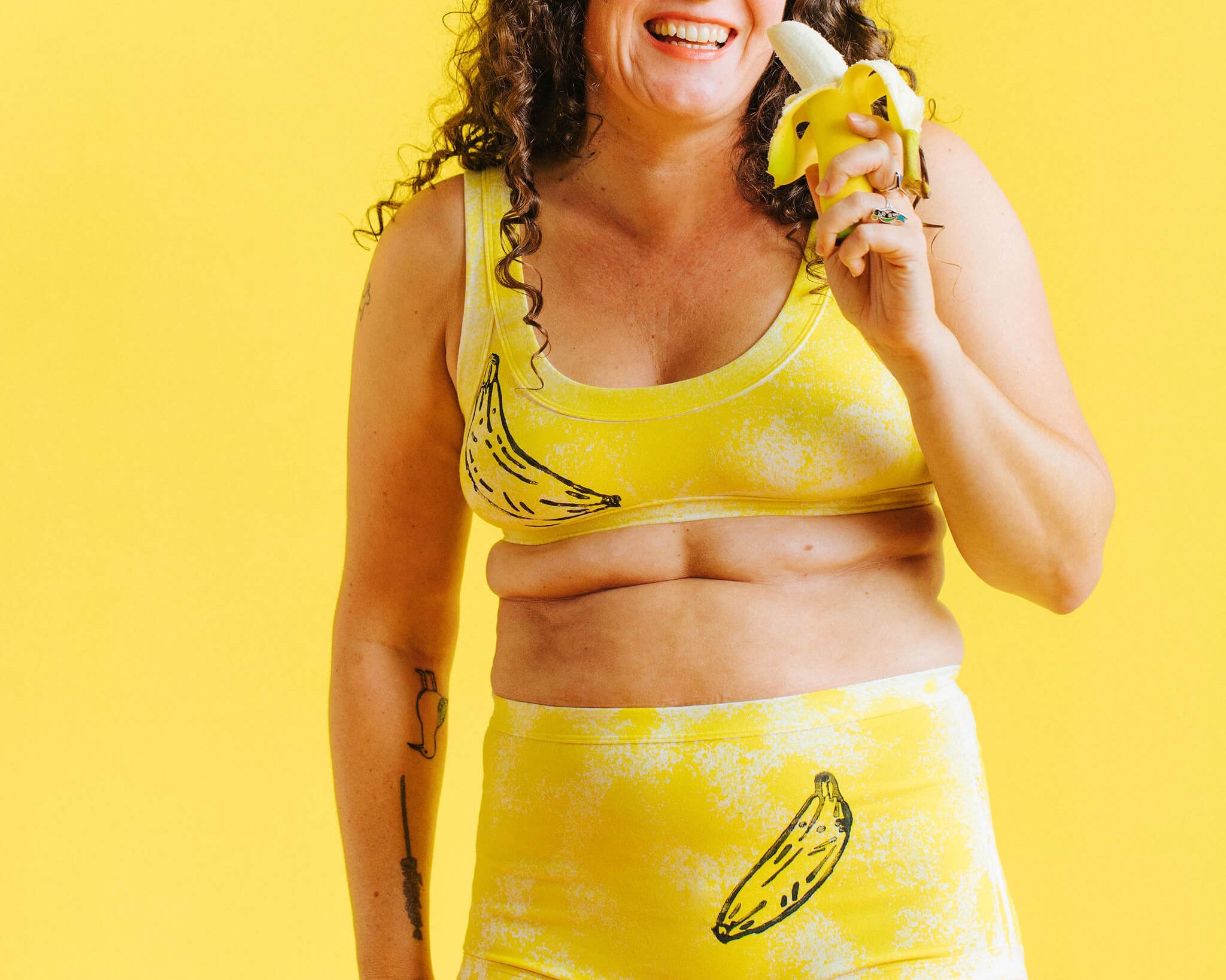 Model wearing Thunderpants Sky Rise style underwear and Bralette in Banana Pitch - yellow with one black banana print.