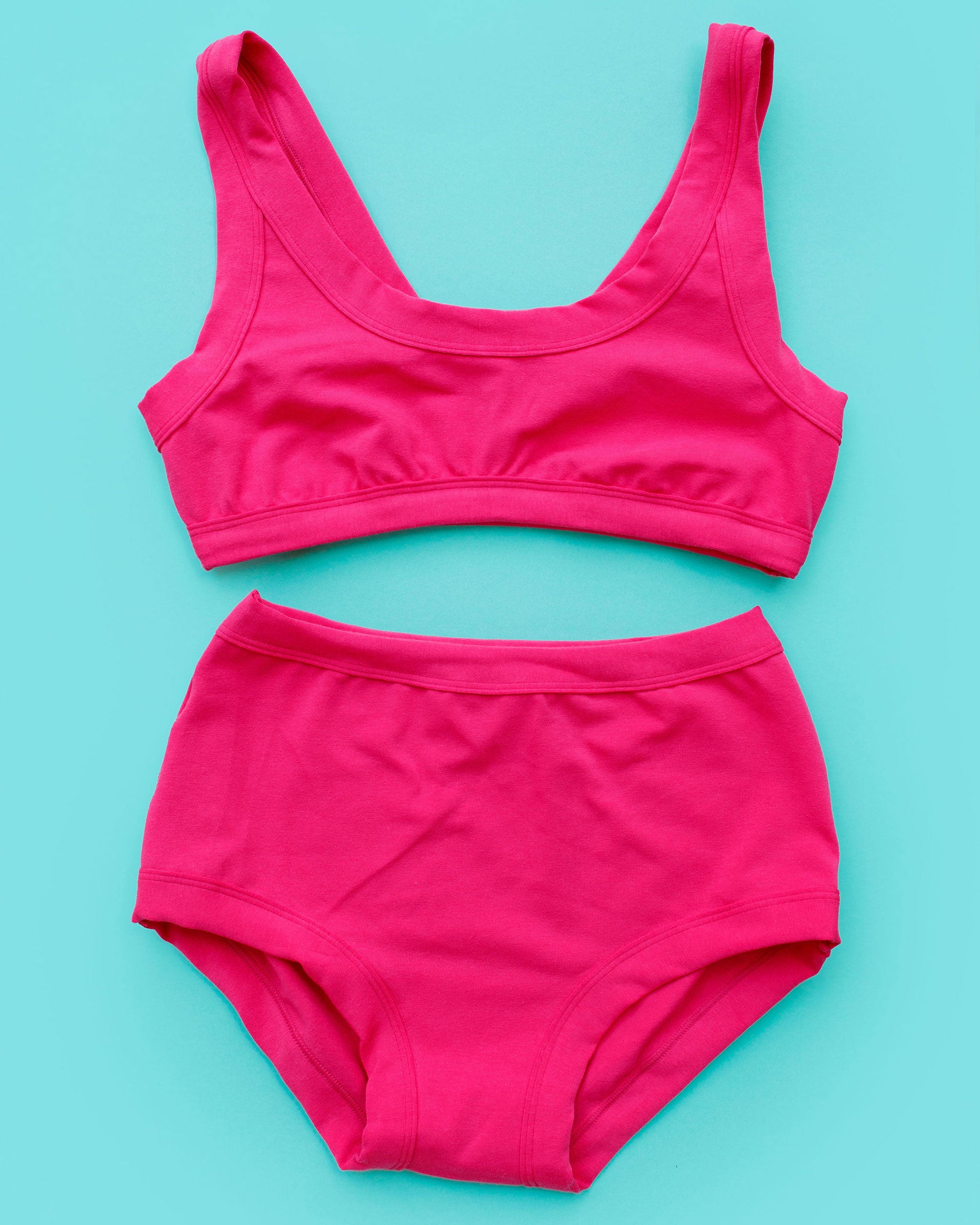 Flat lay of Thunderpants Bralette and Original style underwear in a hot pink color.