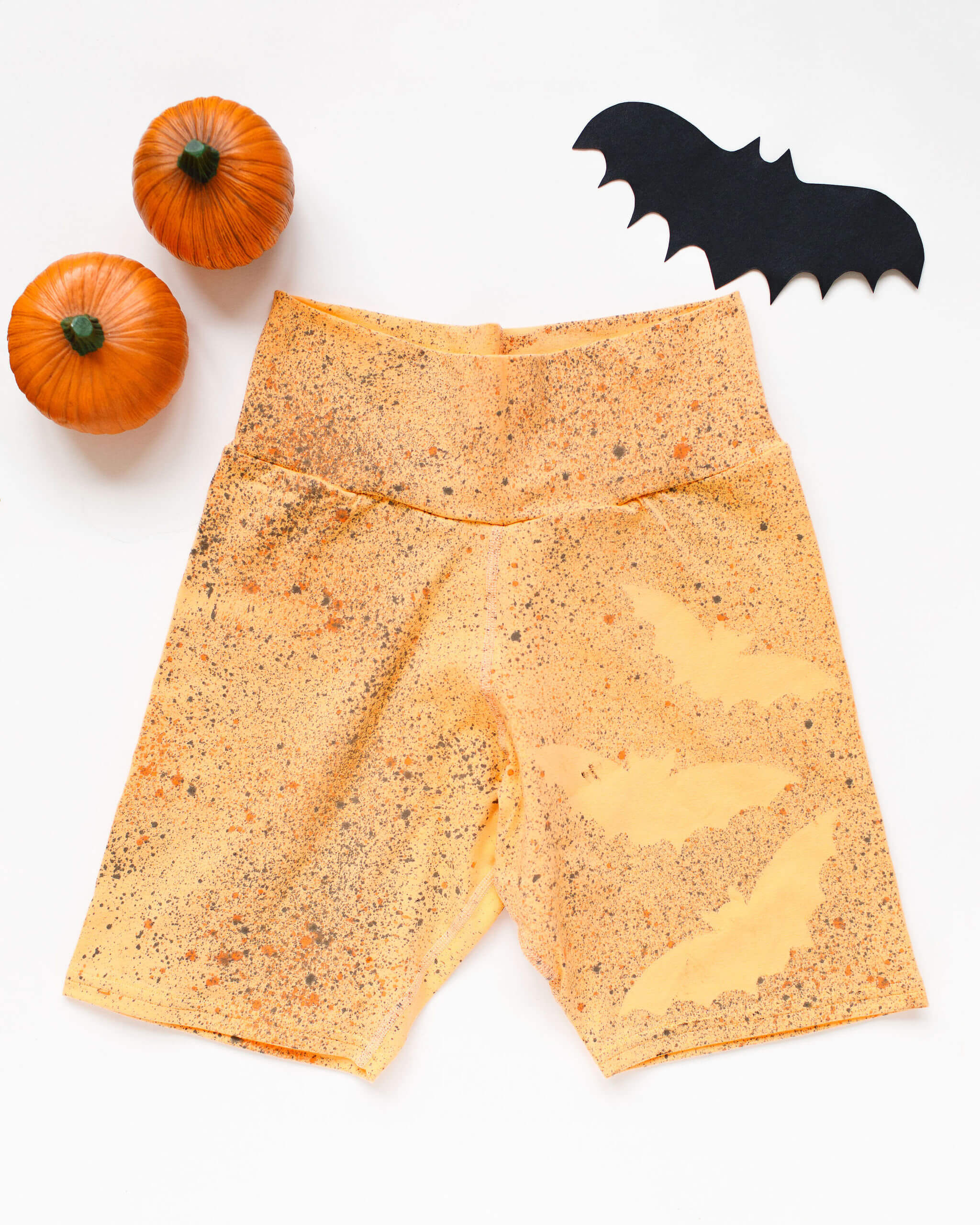 Flat lay of Thunderpants Bike Shorts in Orange Sherbet with bats hand dyed.