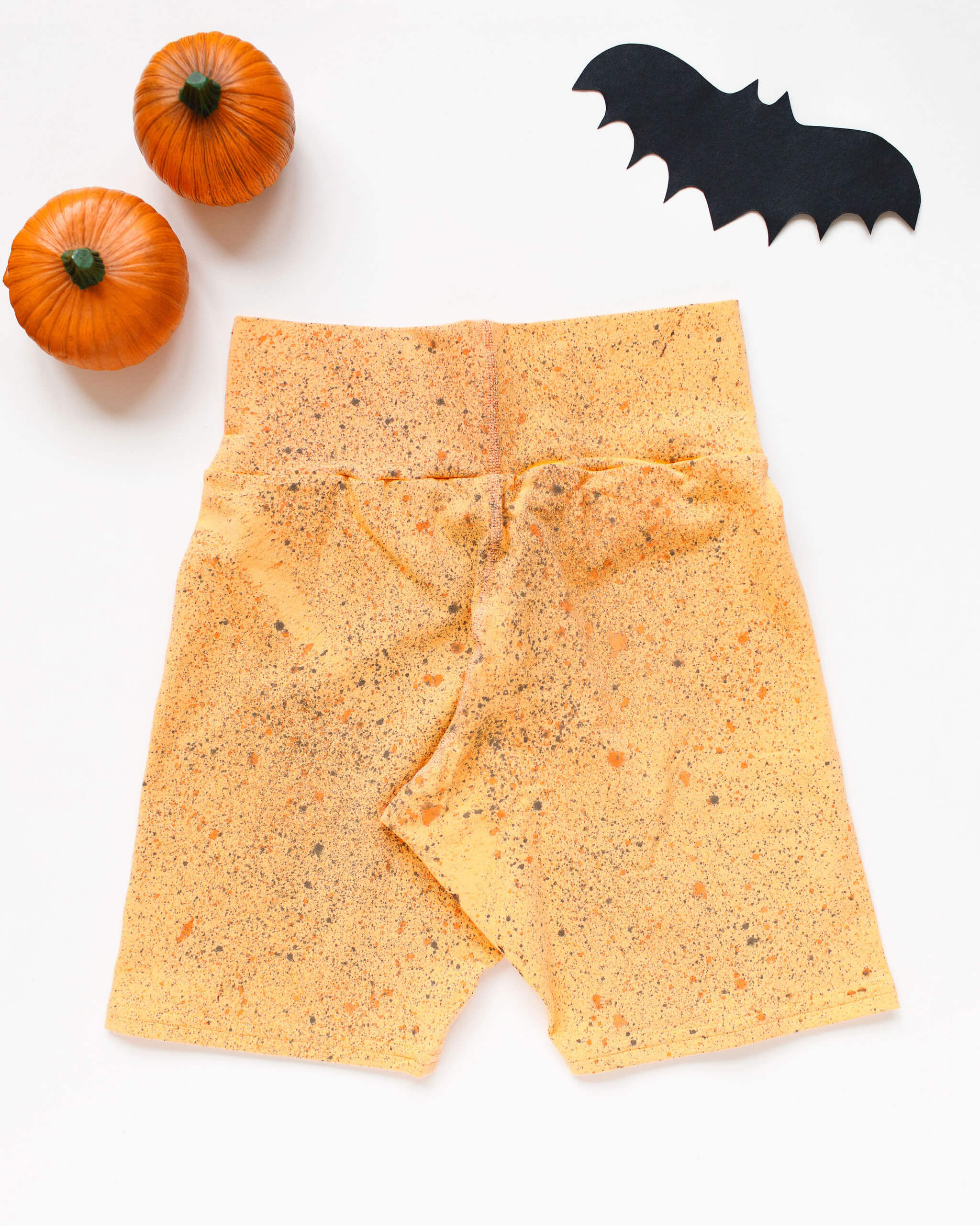 Flat lay of Thunderpants Bike Shorts in Orange Sherbet with bats hand dyed.