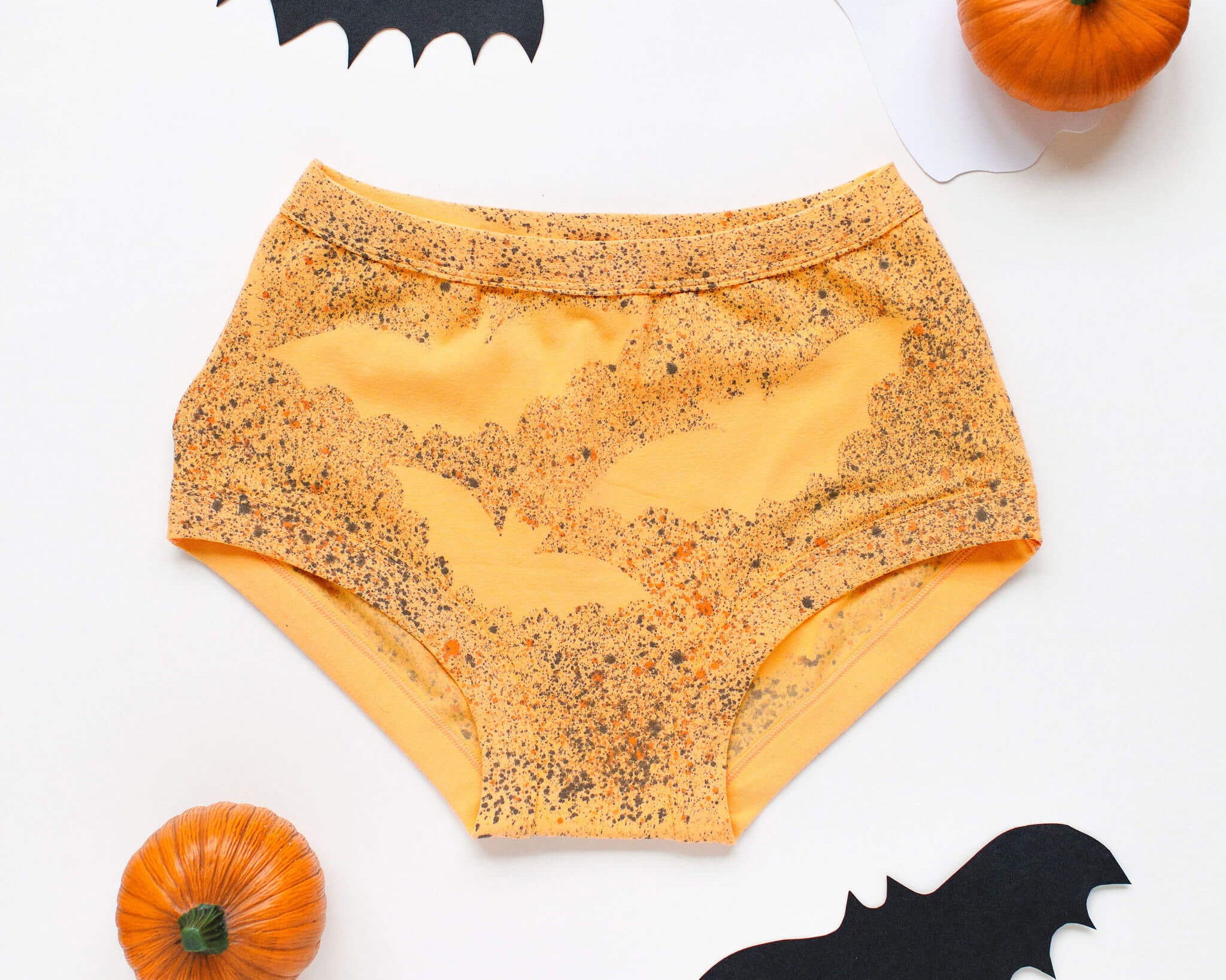 Flat lay of Thunderpants Original style underwear in Orange Sherbet with bat hand dye.