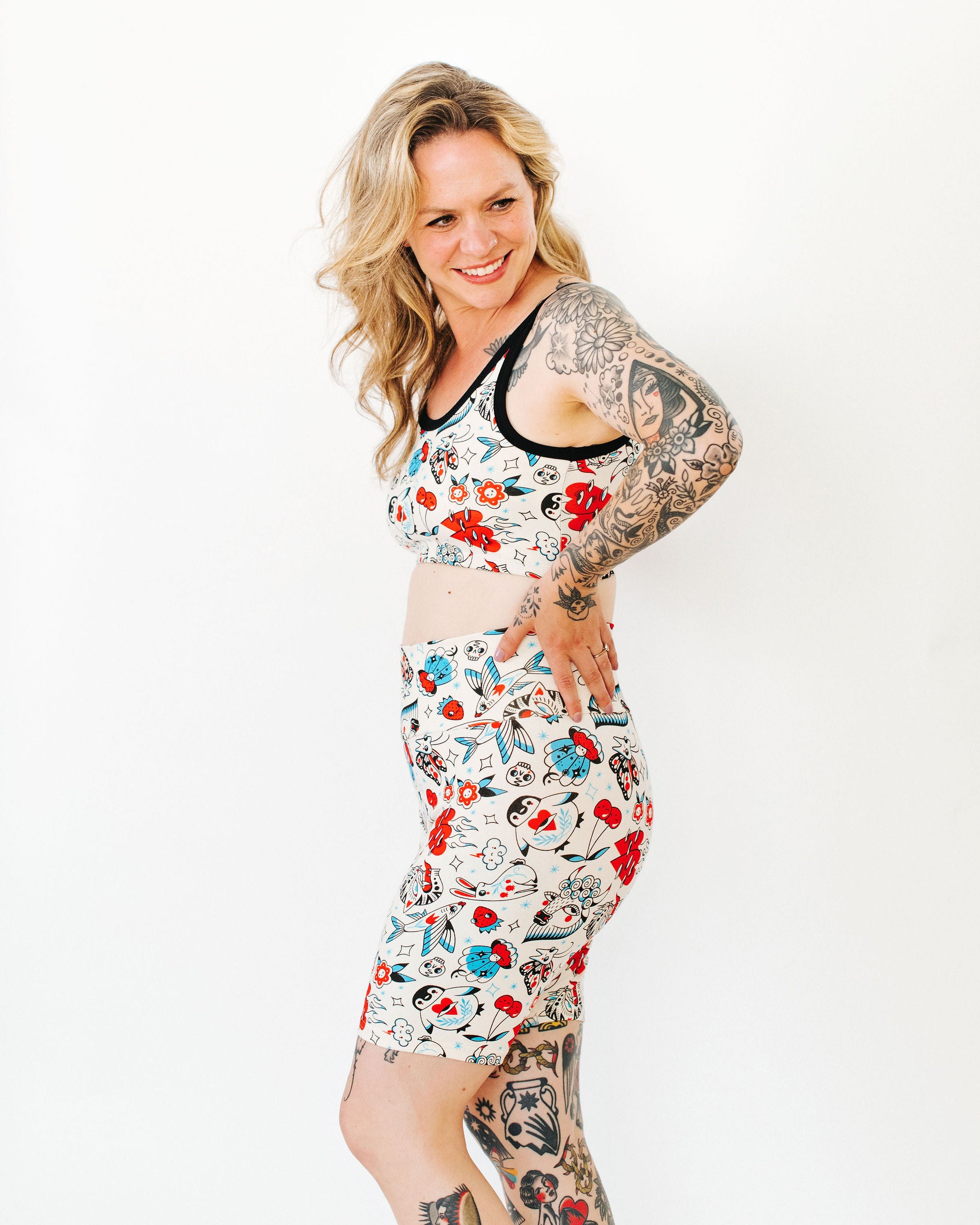 Model wearing Thunderpants Bike Shorts and Longline Bra in Inked Up - a tattoo pattern with black, red, and blue. 