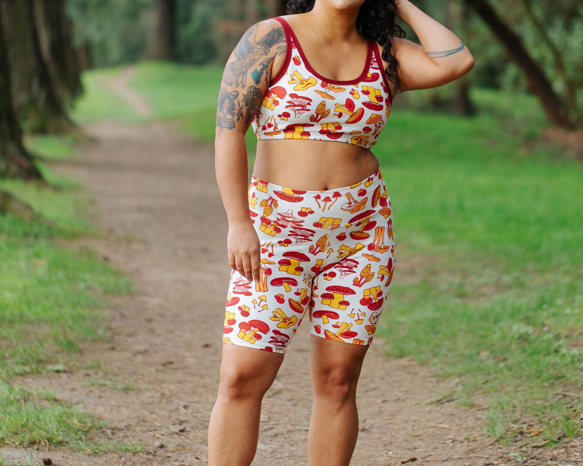 Model wearing Thunderpants Bike Shorts and Longline Bra in Whadda Fungi - red, yellow, and orange mushroom print.