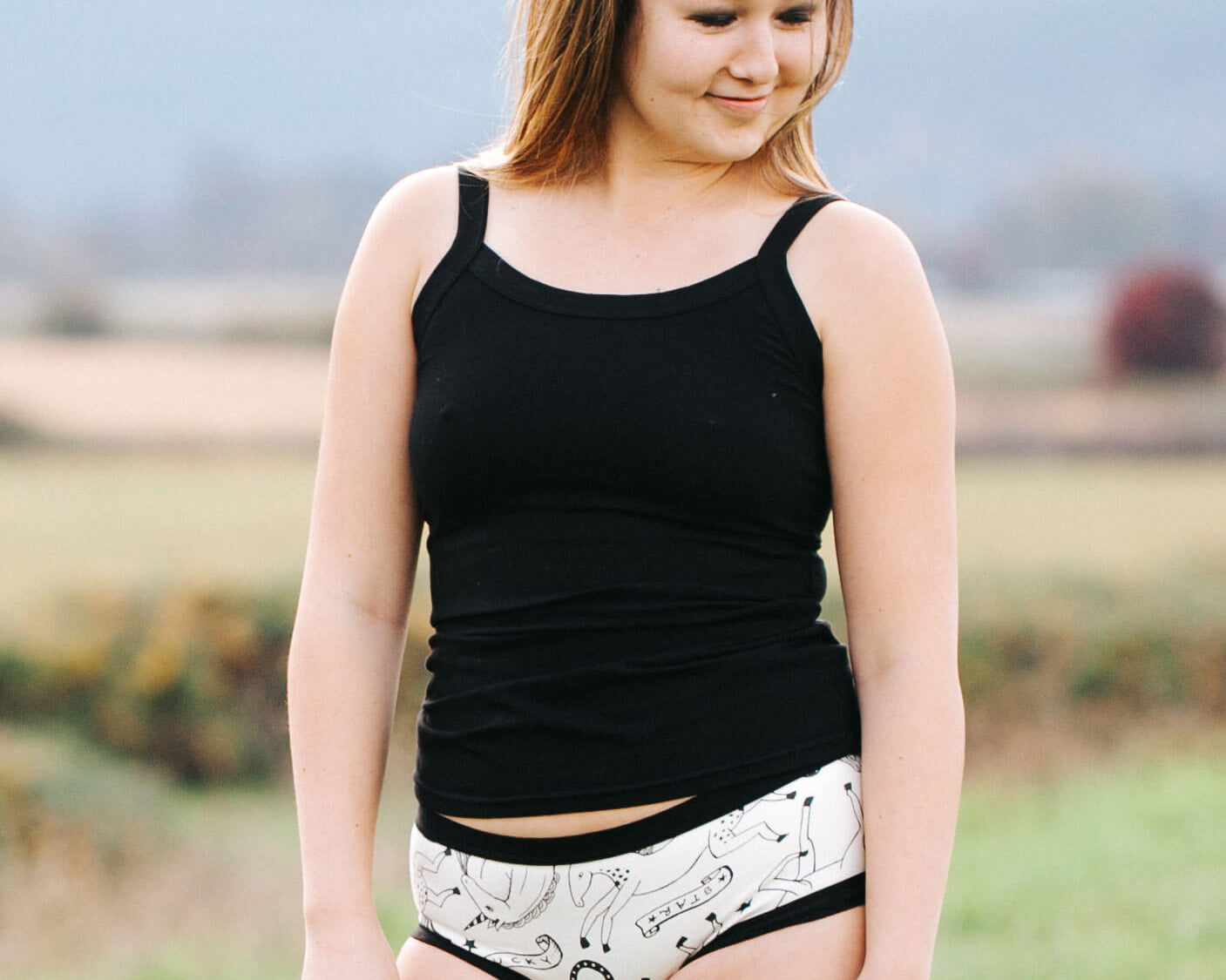 Model outside wearing Thunderpants Camisole in Plain Black and Hipster style underwear in Horses.