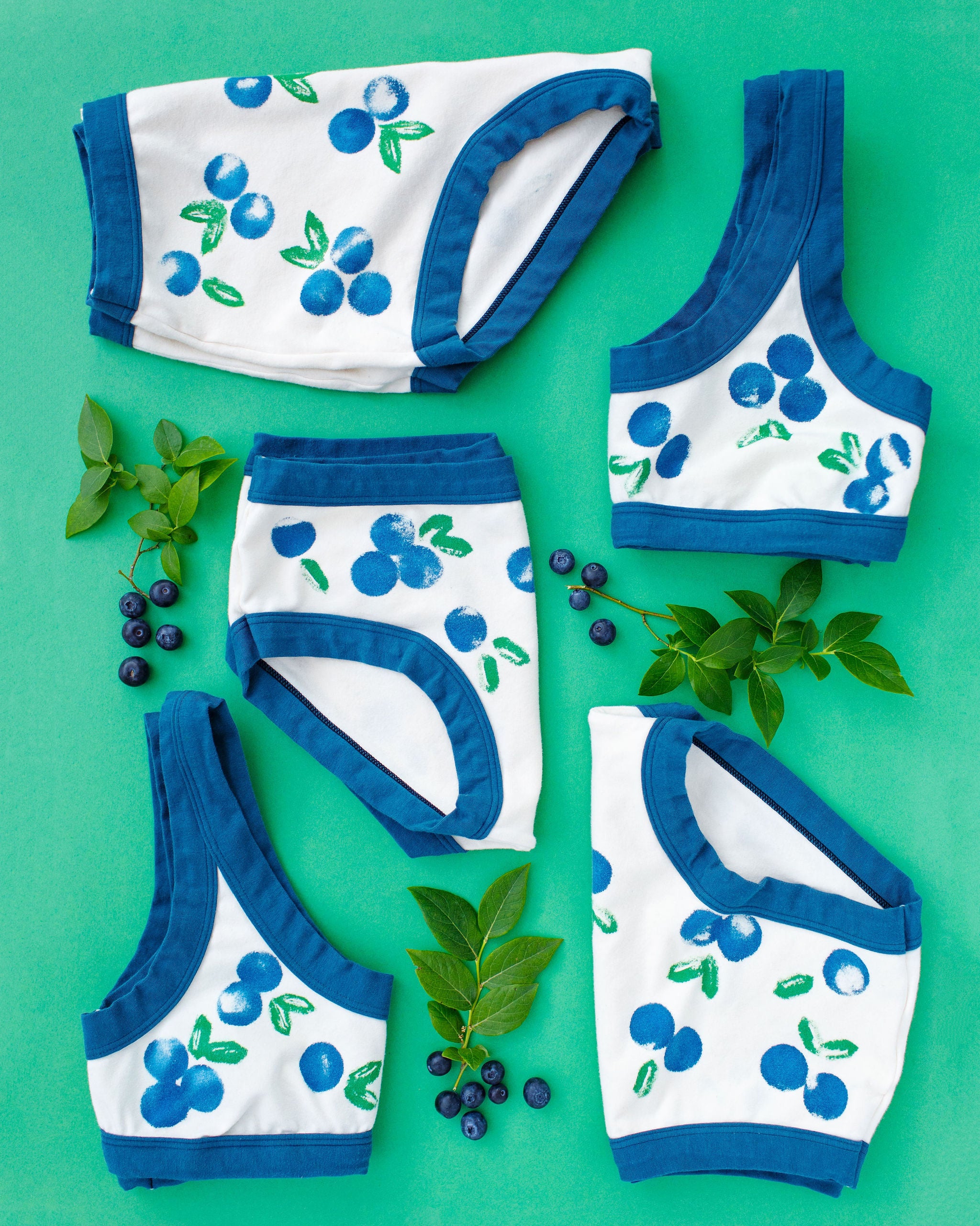 Flat lay of Thunderpants styles with a blue and green Blueberry print and blue binding. 