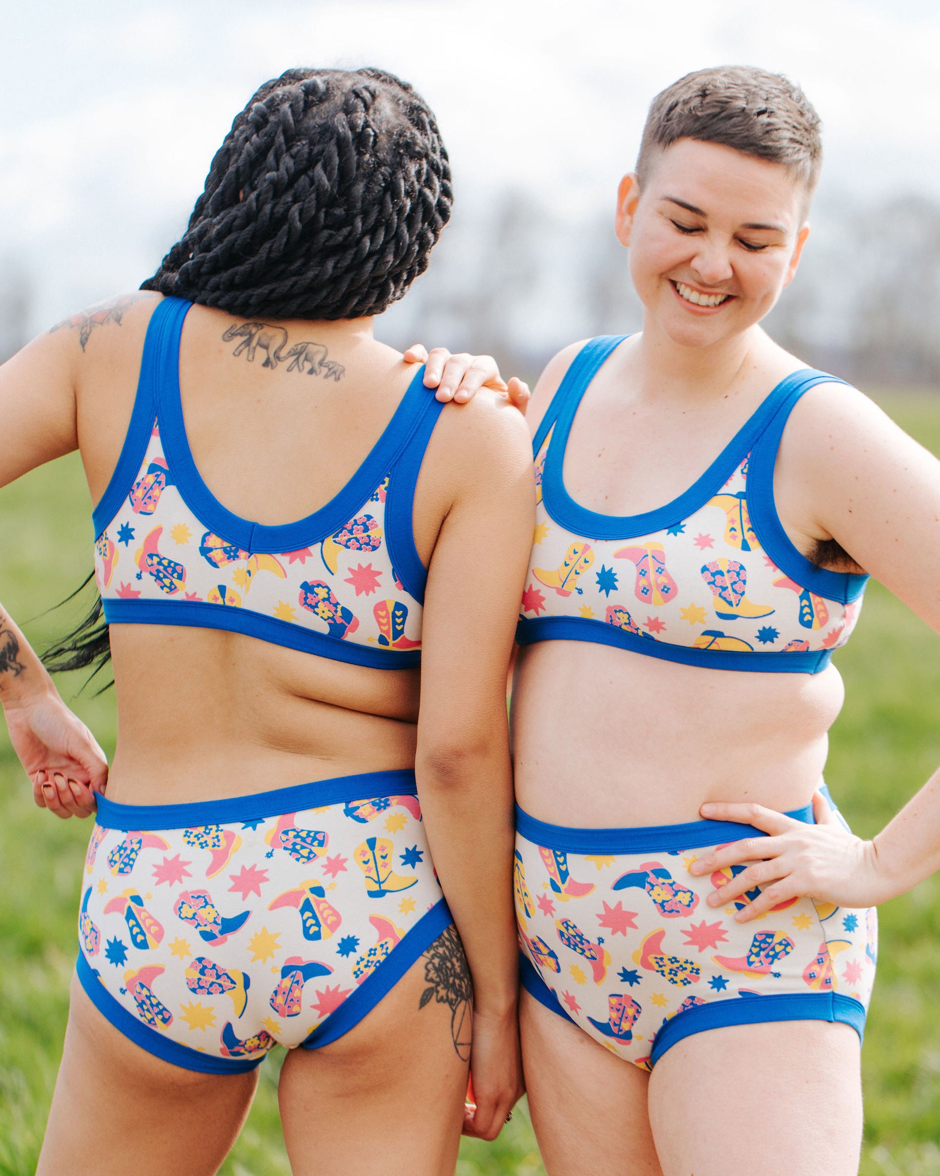 Two models wearing Thunderpants Bralette and underwear sets in Boot Scootin' - fun boots in pink, yellow, and blue.