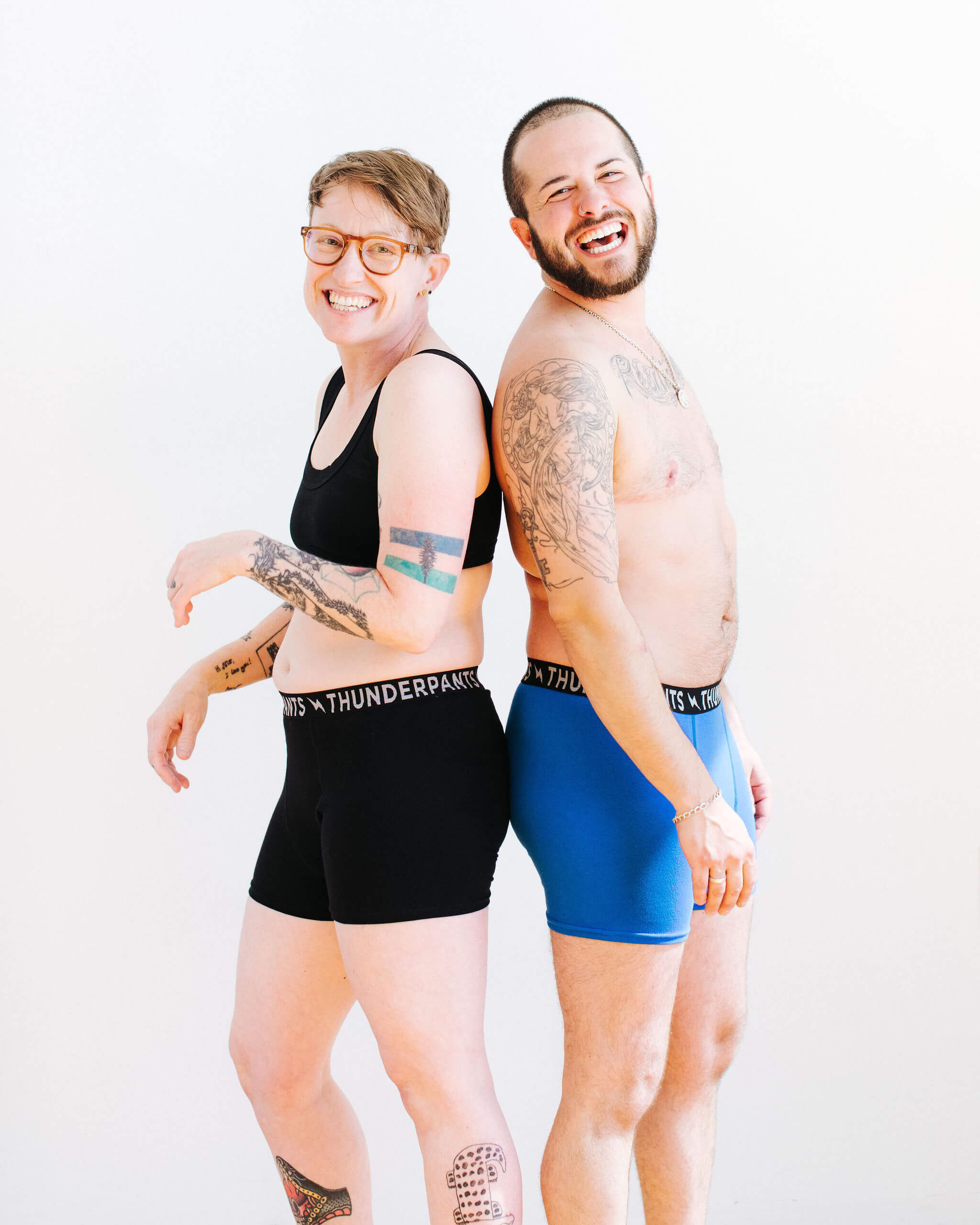 Two models wearing Thunderpants Boxer Brief style underwear in Plain Black and Blueberry Blue.