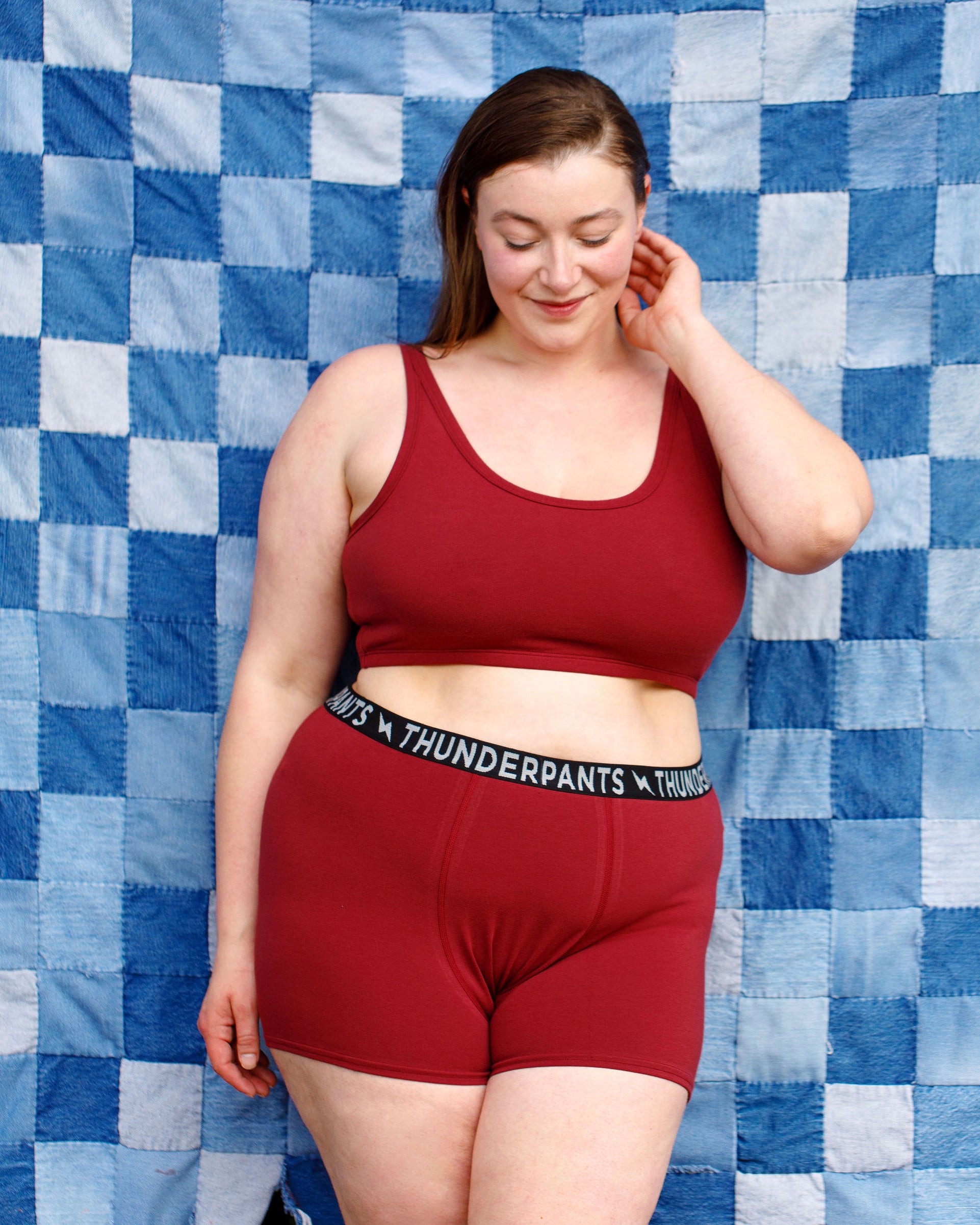 Model wearing Thunderpants Boxer Brief style underwear and Longline Bra in Cabern-YAY - a deep wine red color.