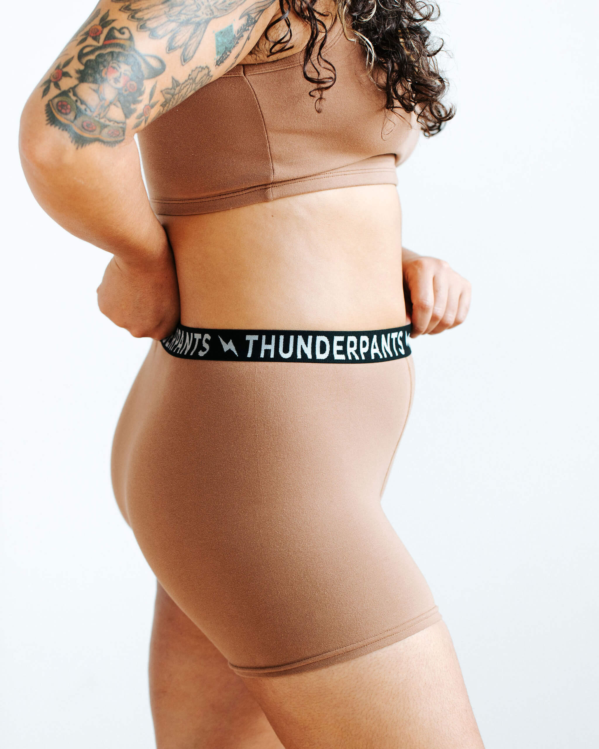 Close up of model wearing Thunderpants Boxer Brief style underwear and Longline Bra in Hazelnut color.