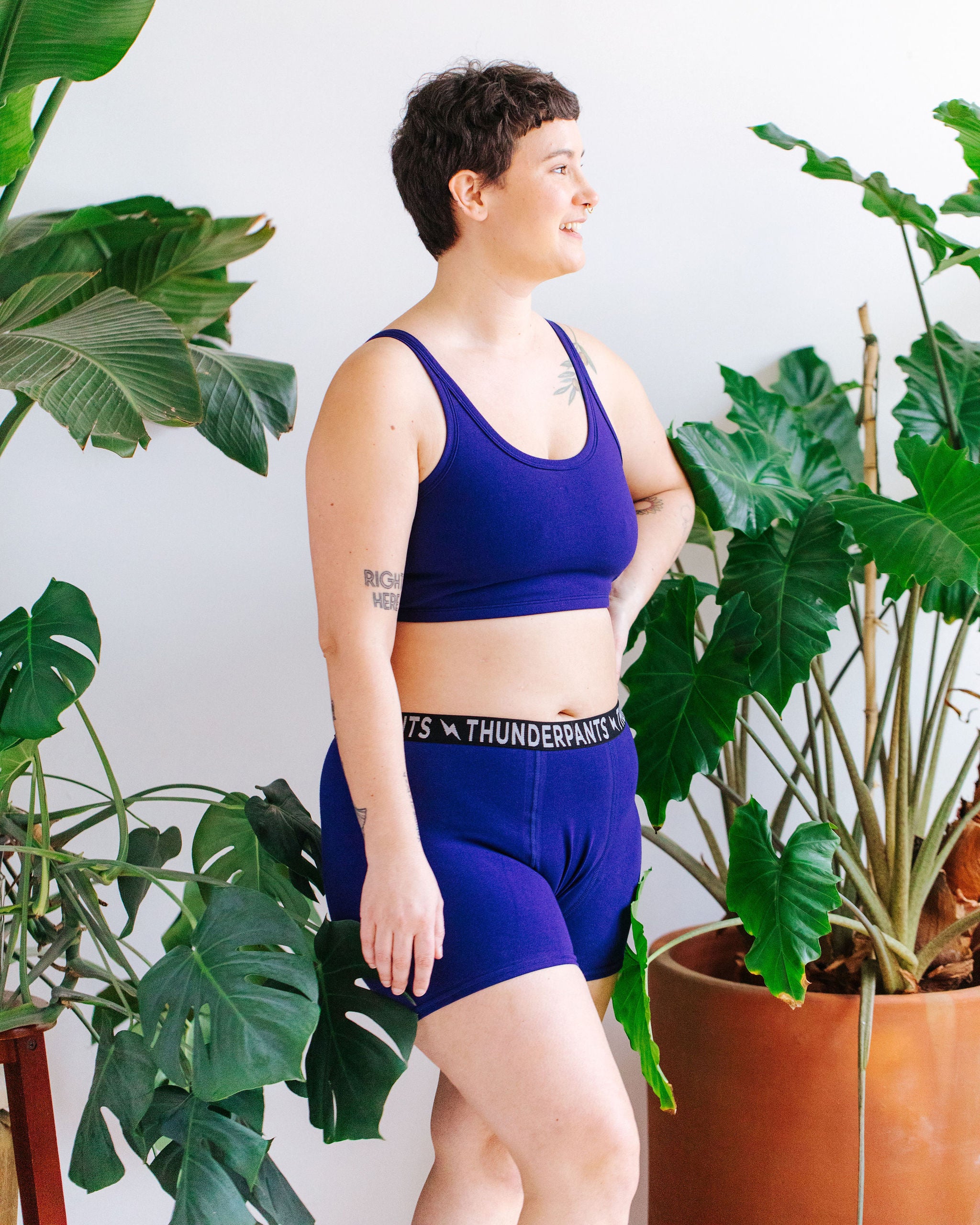 Model wearing Thunderpants Boxer Brief style underwear and Longline Bra in Indigo blue.