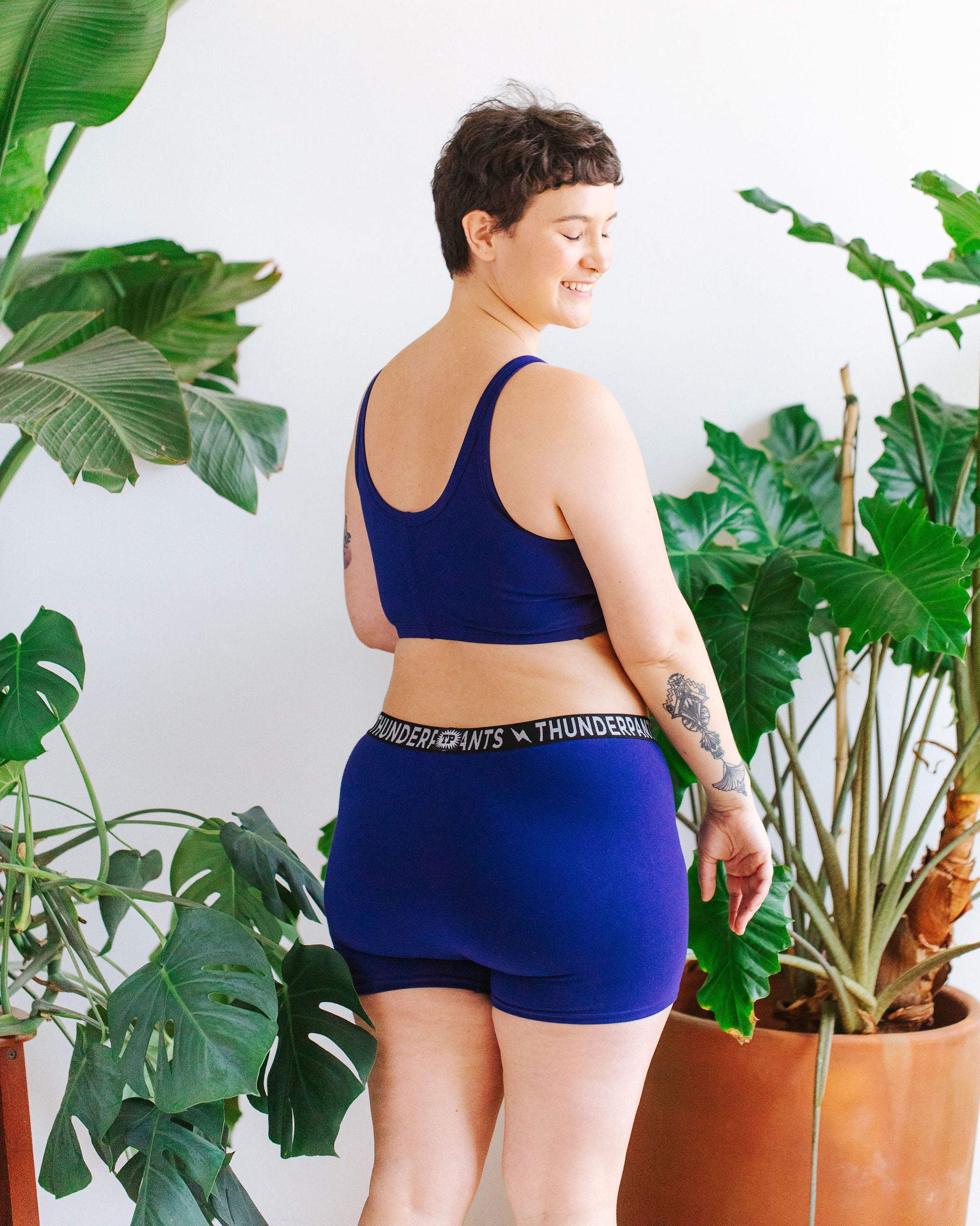 Model wearing Thunderpants Boxer Brief style underwear and Longline Bra in Indigo blue.