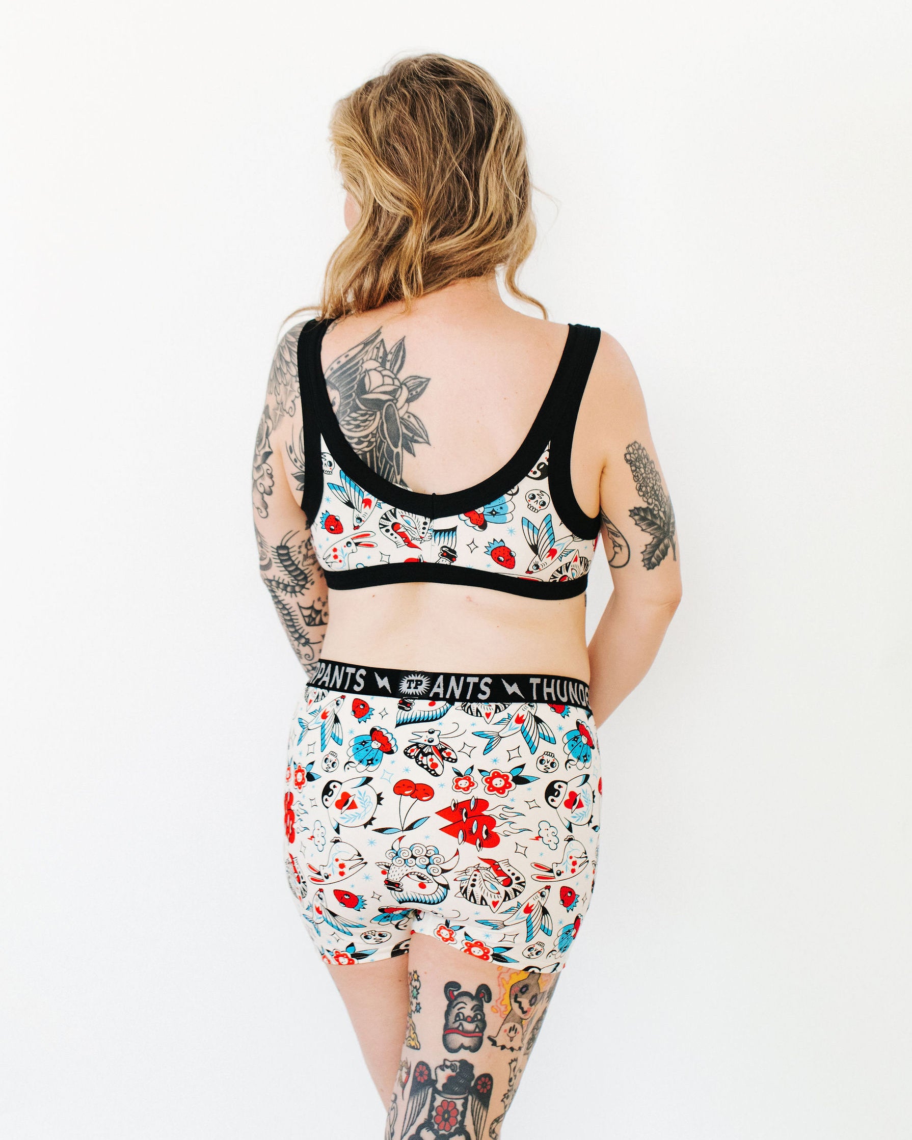 Model wearing Thunderpants Boxer Brief style underwear and Bralette in Inked Up - a tattoo pattern with black, red, and blue. 