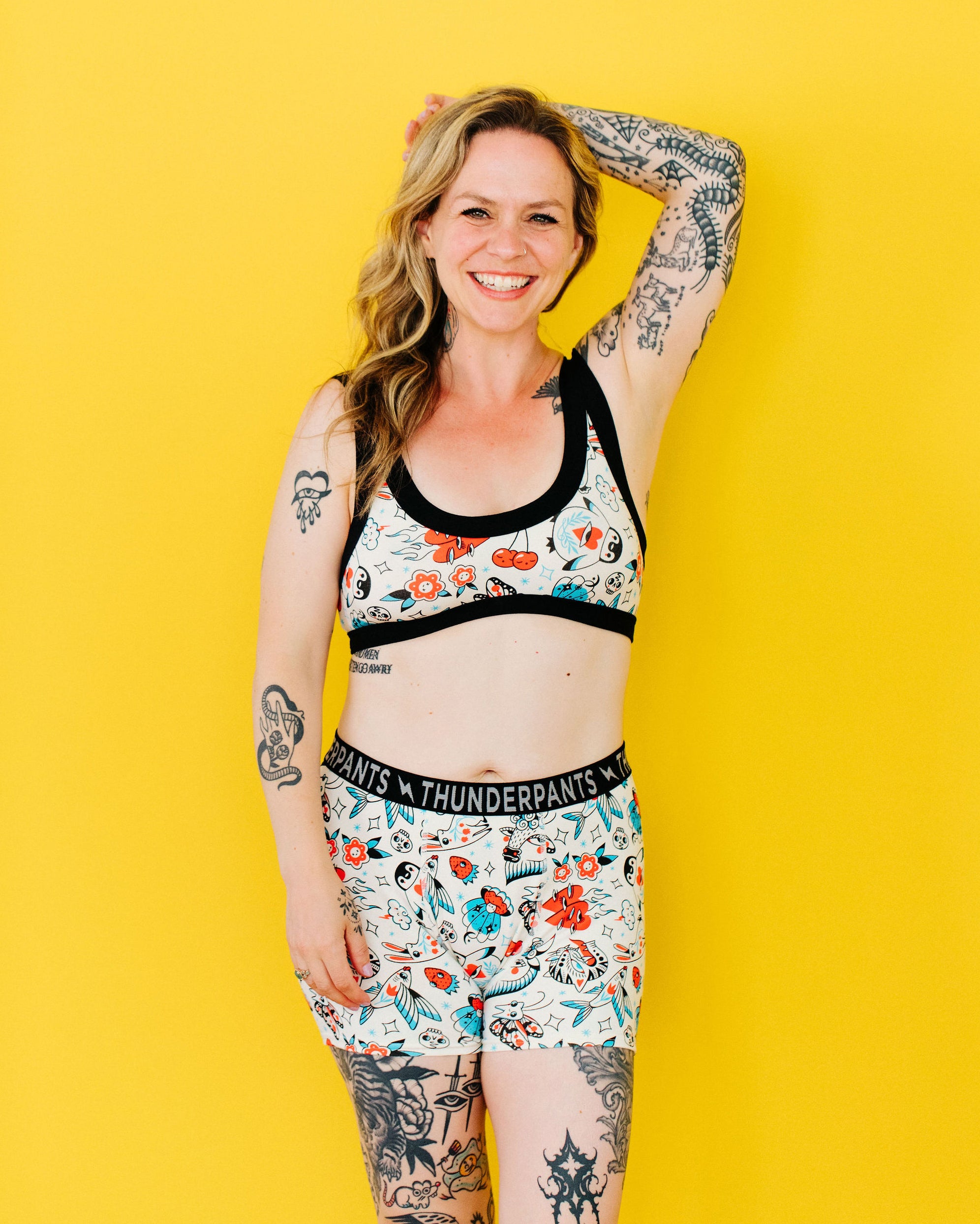 Model wearing Thunderpants Boxer Brief style underwear and Bralette in Inked Up - a tattoo pattern with black, red, and blue. 