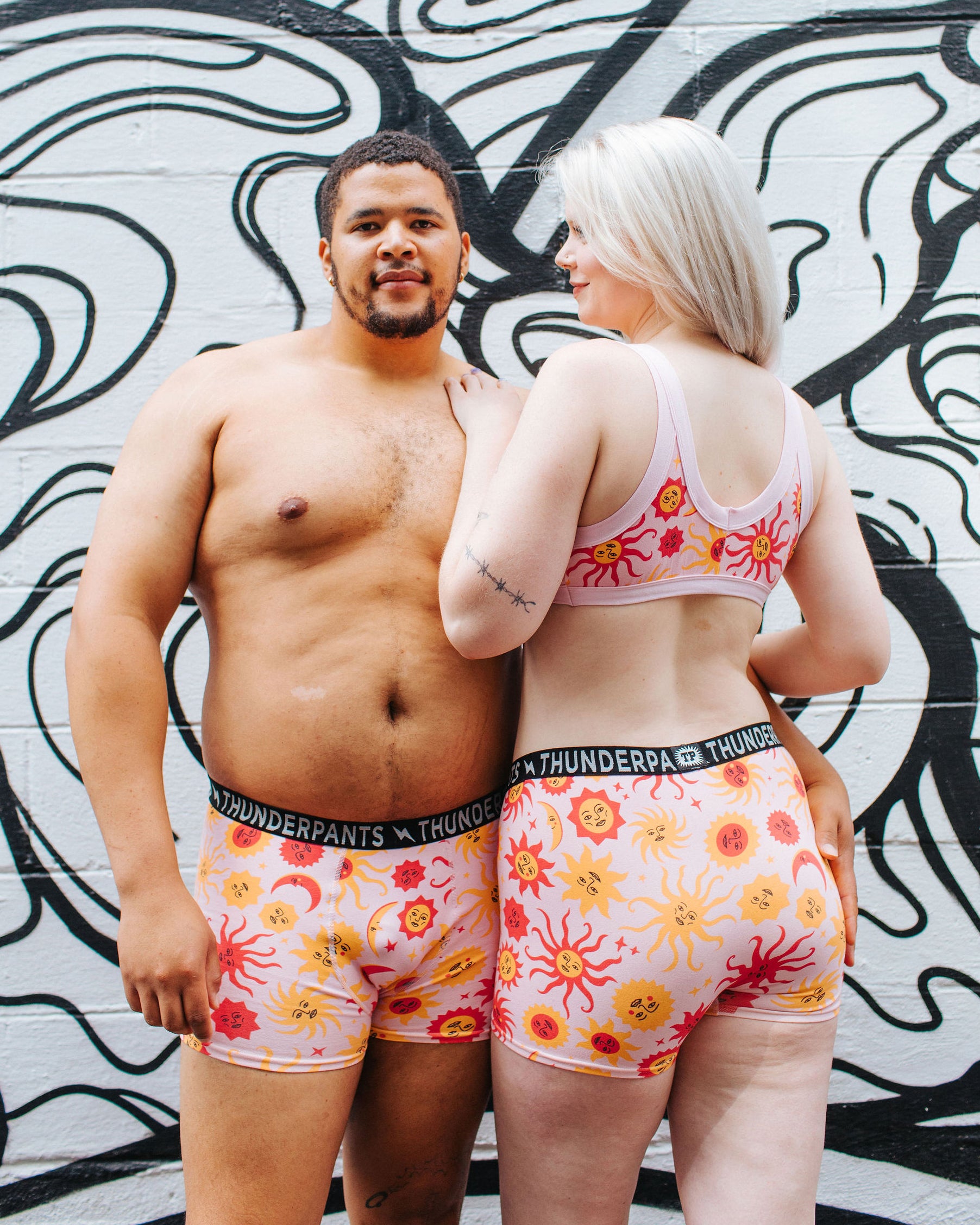 Models wearing Thunderpants Boxer Brief style underwear and Bralette in Luna y Sol print - pink, yellow, and orange suns and moons.