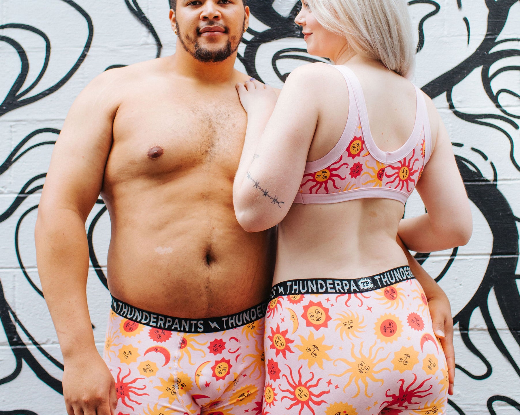 Models wearing Thunderpants Boxer Brief style underwear and Bralette in Luna y Sol print - pink, yellow, and orange suns and moons.