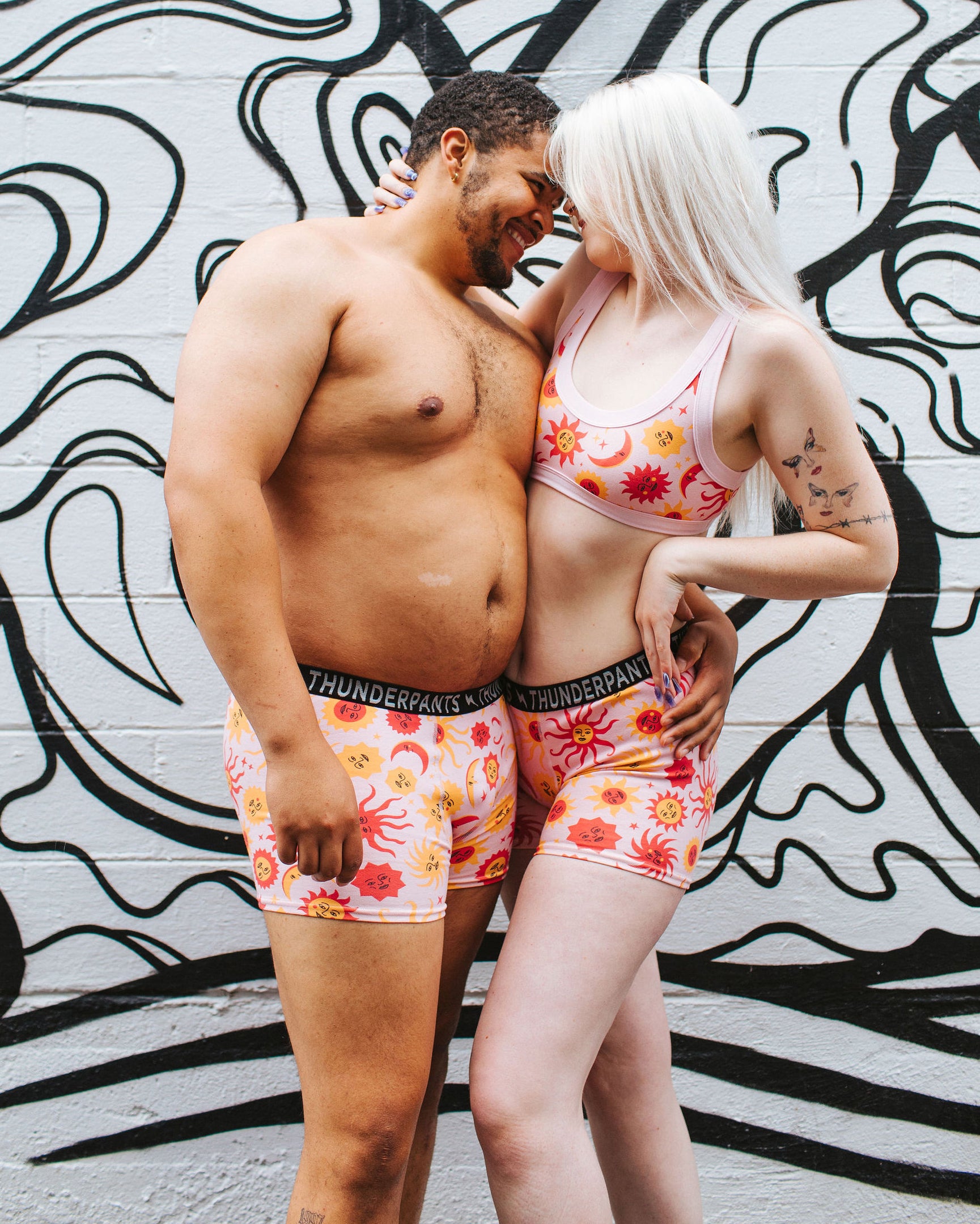 Models wearing Thunderpants Boxer Brief style underwear and Bralette in Luna y Sol print - pink, yellow, and orange suns and moons.
