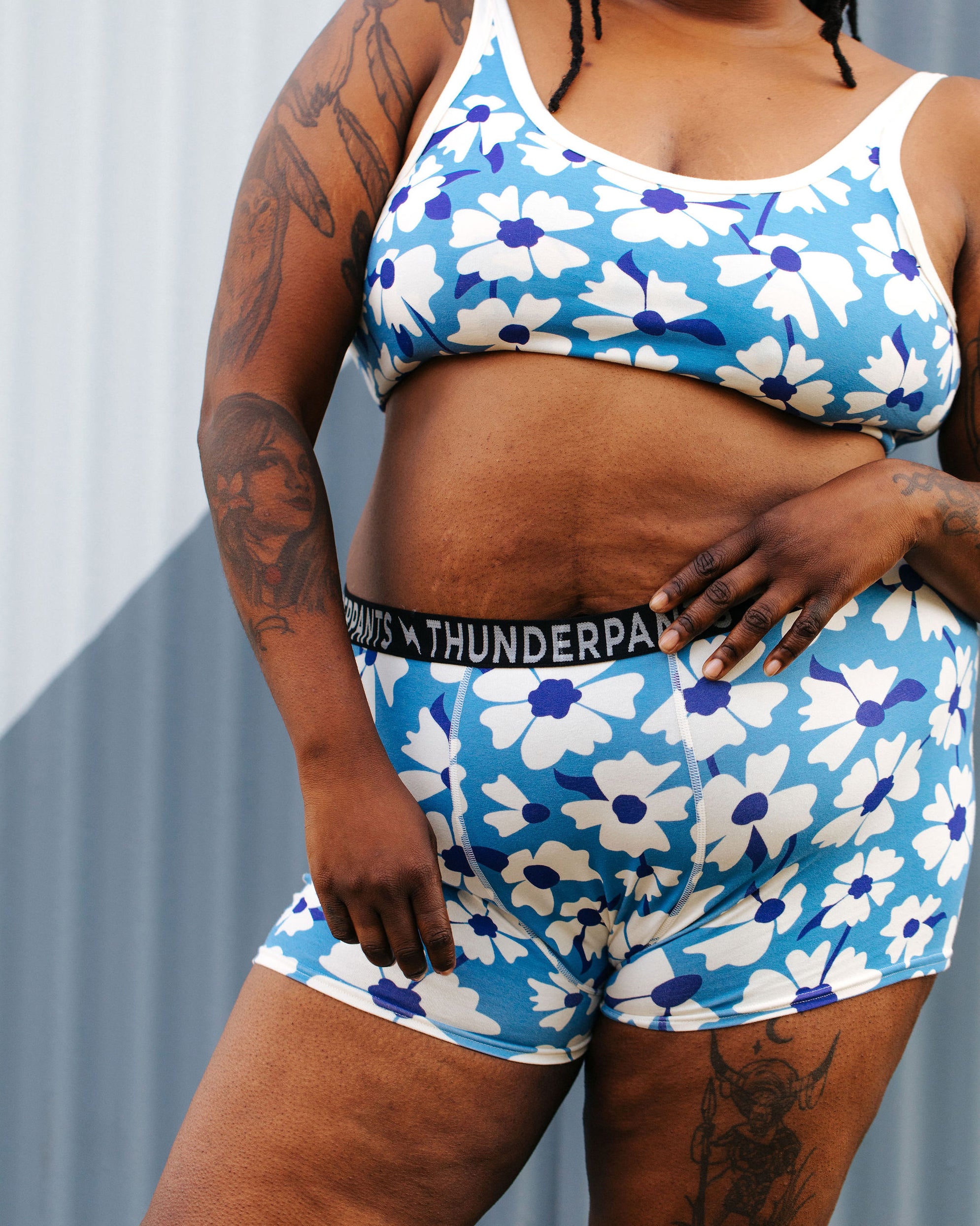 Model wearing Thunderpants Boxer Brief style underwear and Longline Bra in Moody Blooms - white and blue flowers with blue background.