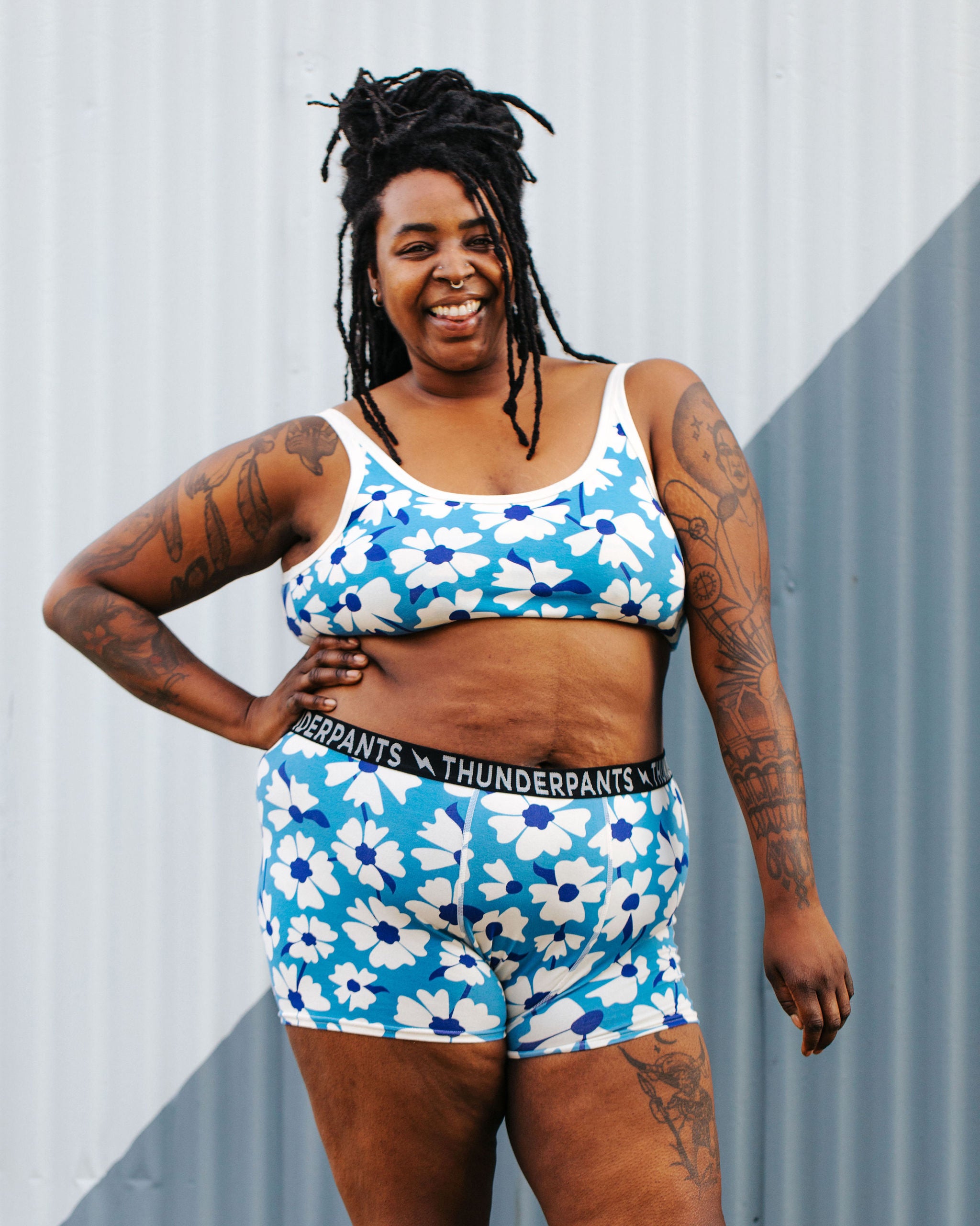 Model wearing Thunderpants Boxer Brief style underwear and Longline Bra in Moody Blooms - white and blue flowers with blue background.