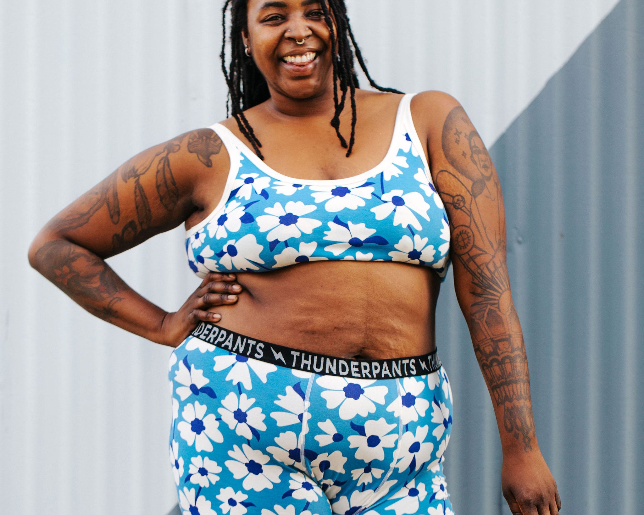 Model wearing Thunderpants Boxer Brief style underwear and Longline Bra in Moody Blooms - white and blue flowers with blue background.