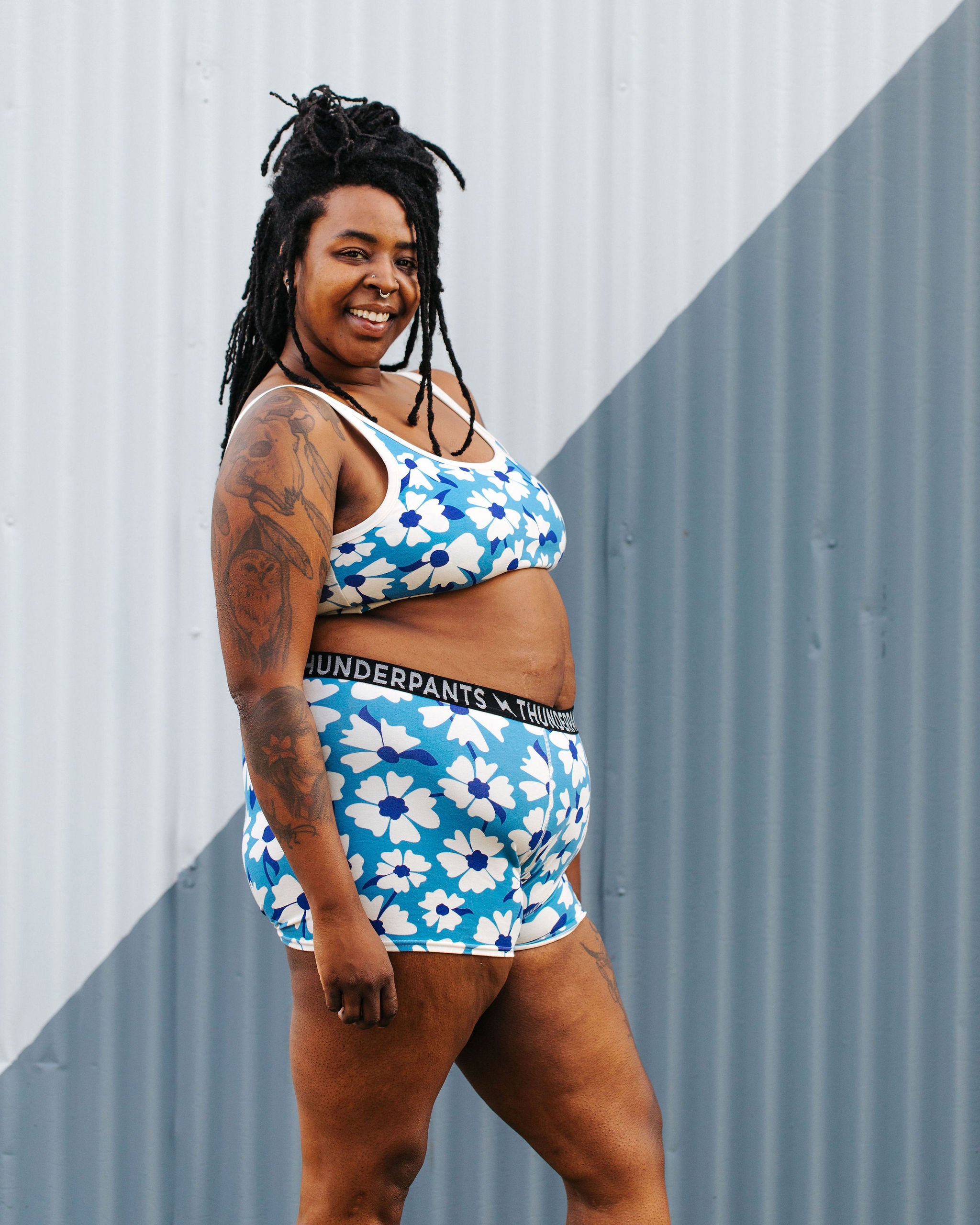 Model wearing Thunderpants Boxer Brief style underwear and Longline Bra in Moody Blooms - white and blue flowers with blue background.