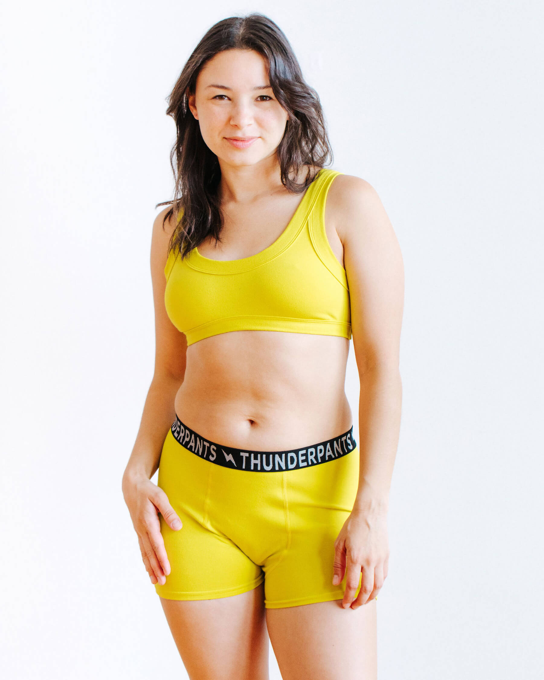 Model wearing Thunderpants Boxer Brief style underwear and Bralette in Star Fruit color - a chartreuse yellow.