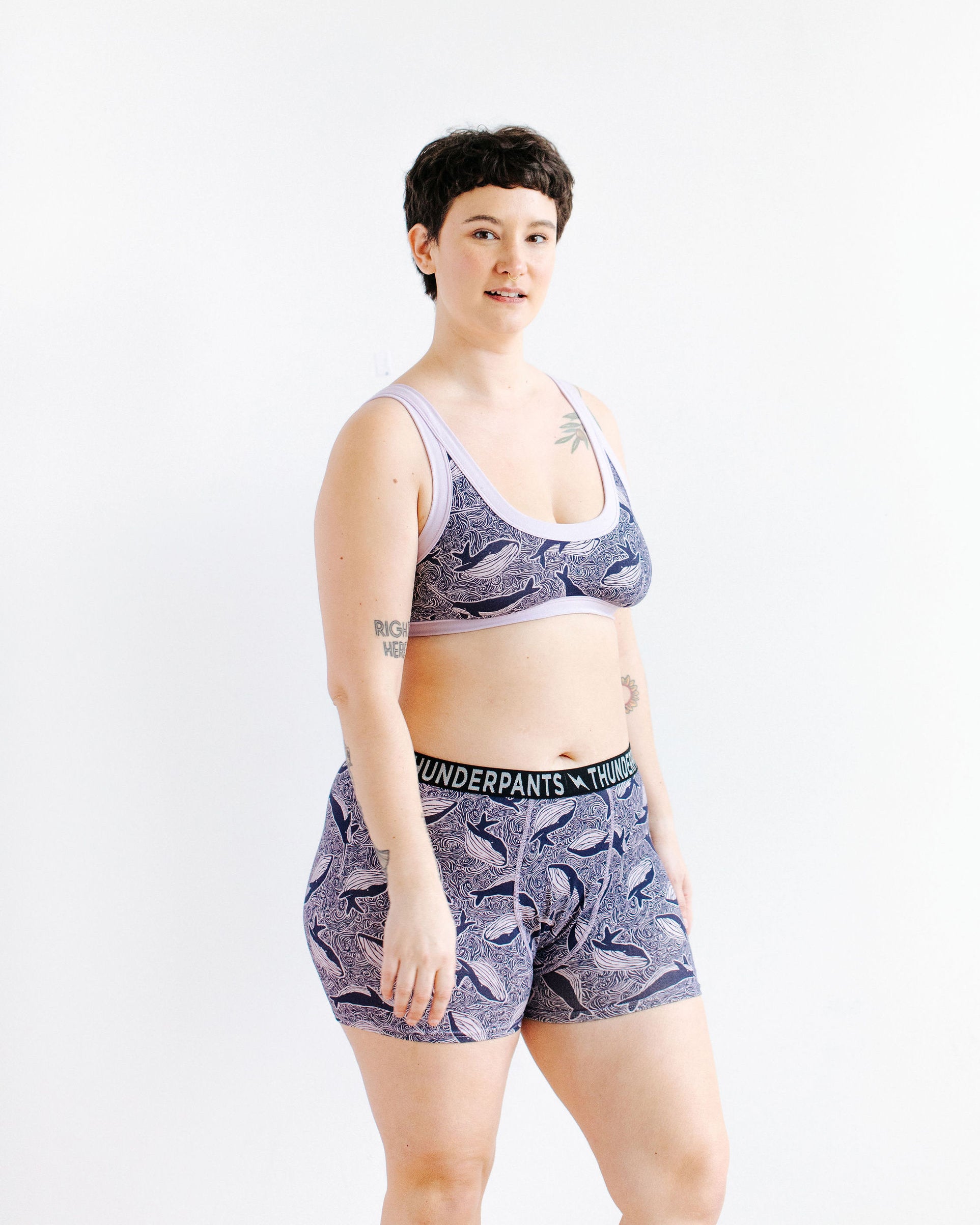 Model wearing Thunderpants Boxer Brief style underwear and Bralette in Whale, Whale, Whale print - indigo whales on lavender.