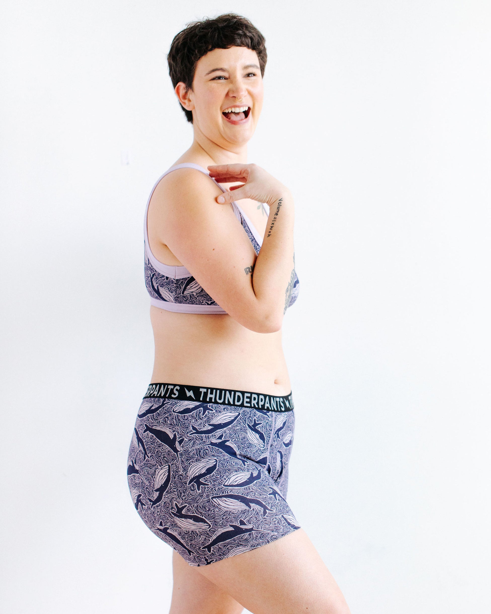 Model wearing Thunderpants Boxer Brief style underwear and Bralette in Whale, Whale, Whale print - indigo whales on lavender.