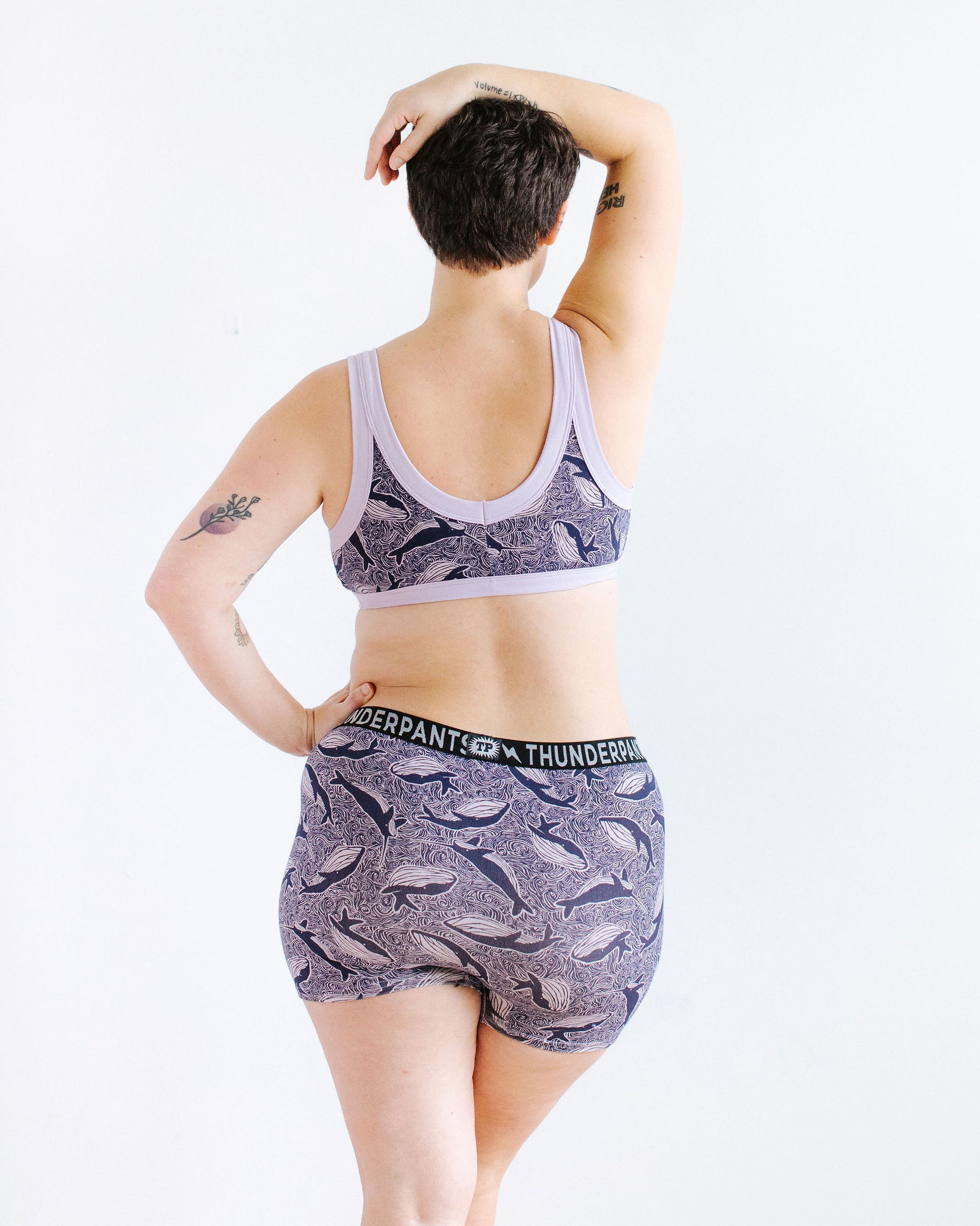 Model wearing Thunderpants Boxer Brief style underwear and Bralette in Whale, Whale, Whale print - indigo whales on lavender.