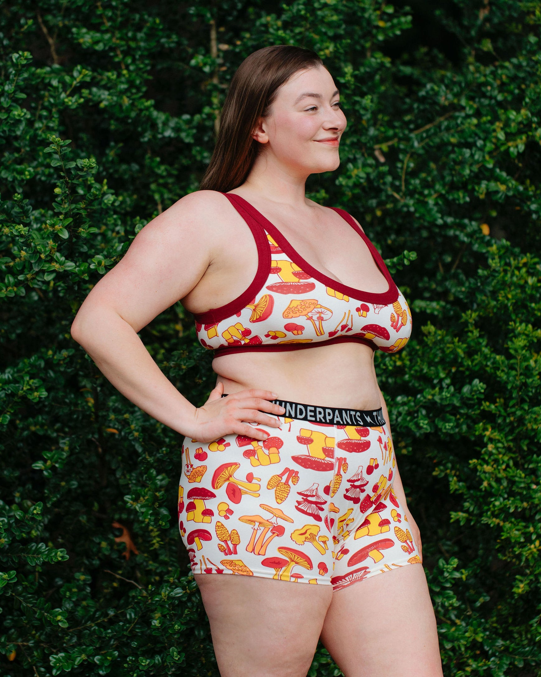 Model wearing Thunderpants Boxer Brief style underwear  and Bralette in Whadda Fungi - red, yellow, and orange mushroom print.