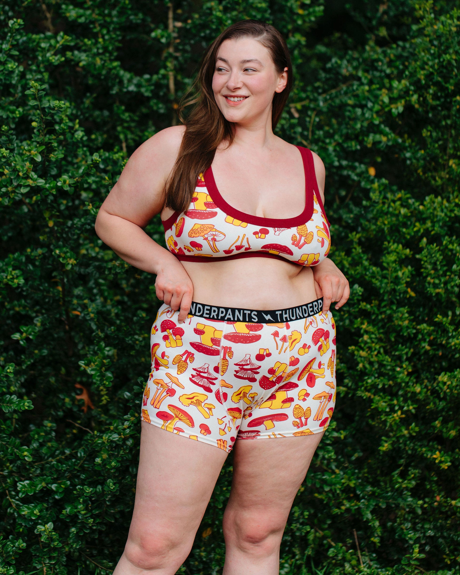 Model wearing Thunderpants Boxer Brief style underwear  and Bralette in Whadda Fungi - red, yellow, and orange mushroom print.