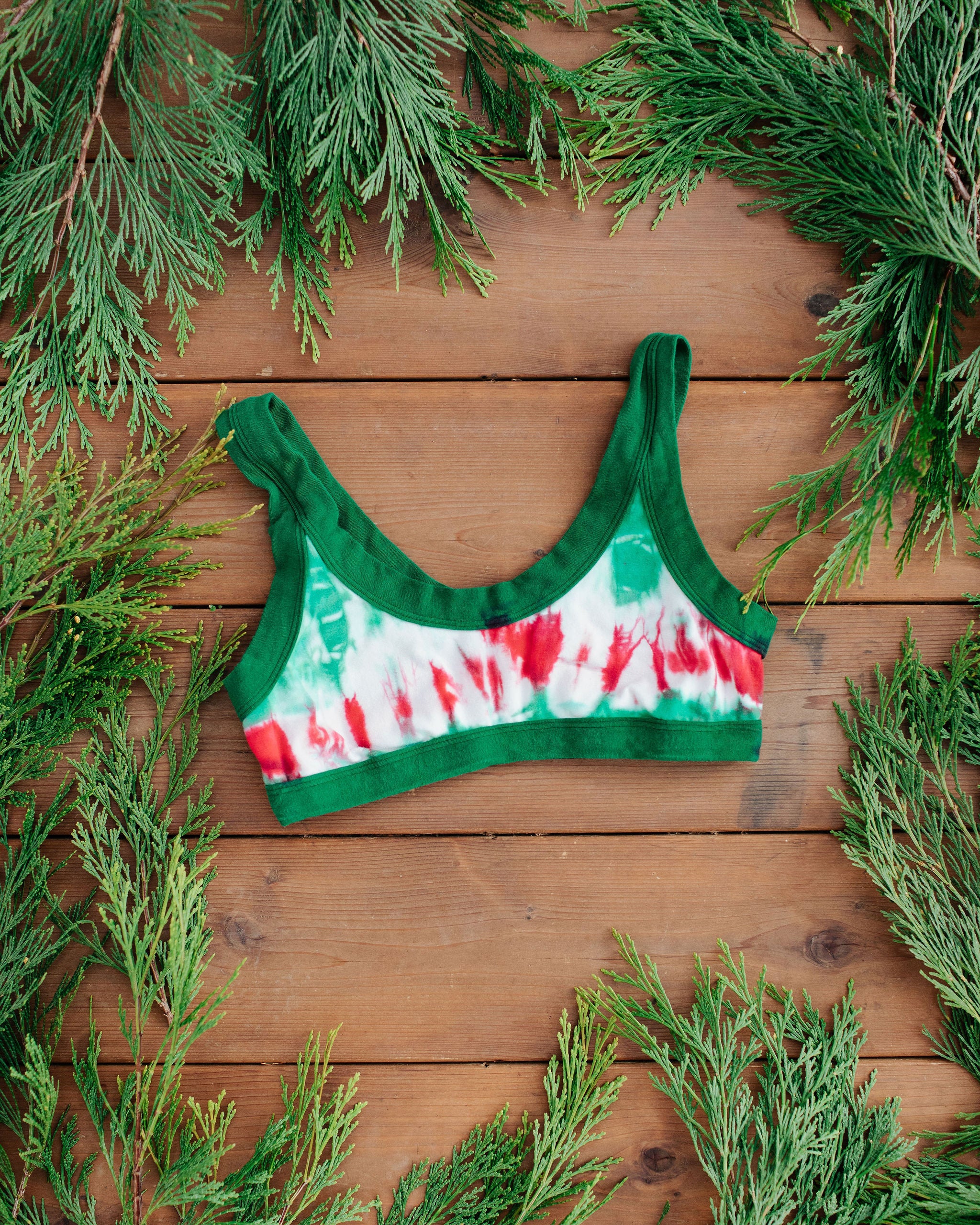 Flat lay of Thunderpants Bralette in Holiday Dye - red and green tie dye with green binding. 
