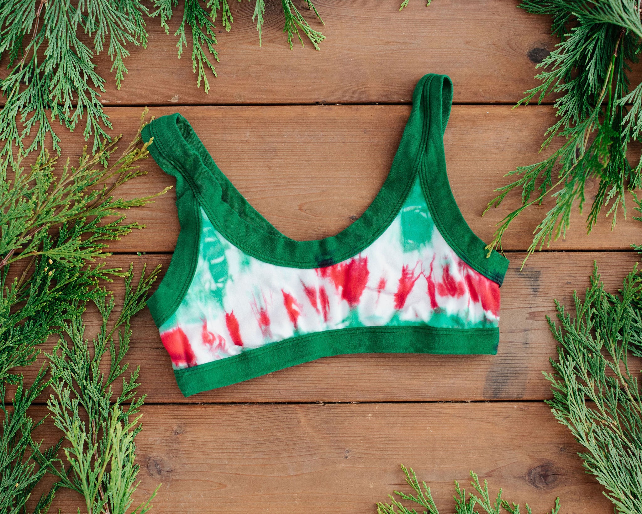 Flat lay of Thunderpants Bralette in Holiday Dye - red and green tie dye with green binding. 