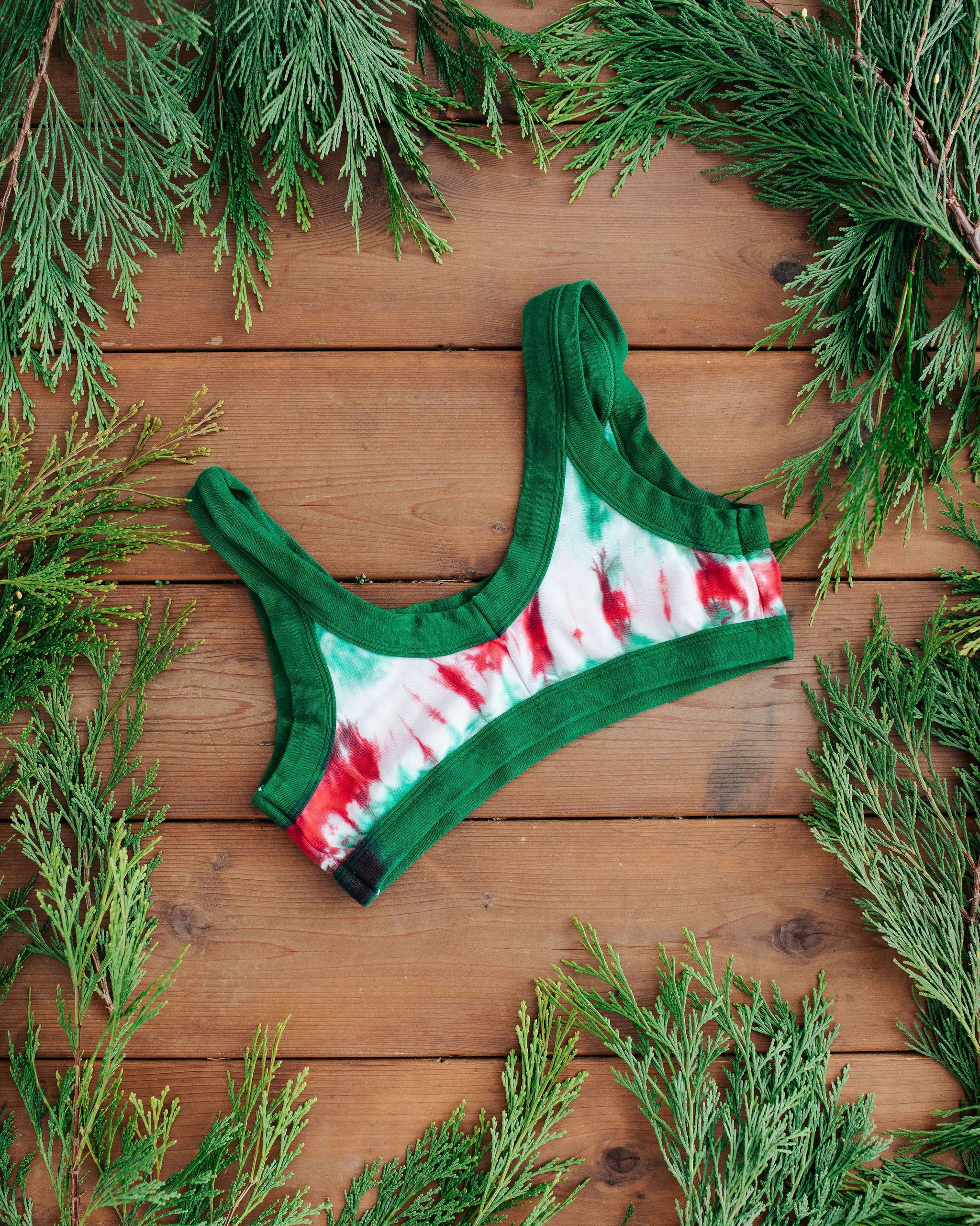 Flat lay of Thunderpants Bralette in Holiday Dye - red and green tie dye with green binding. 