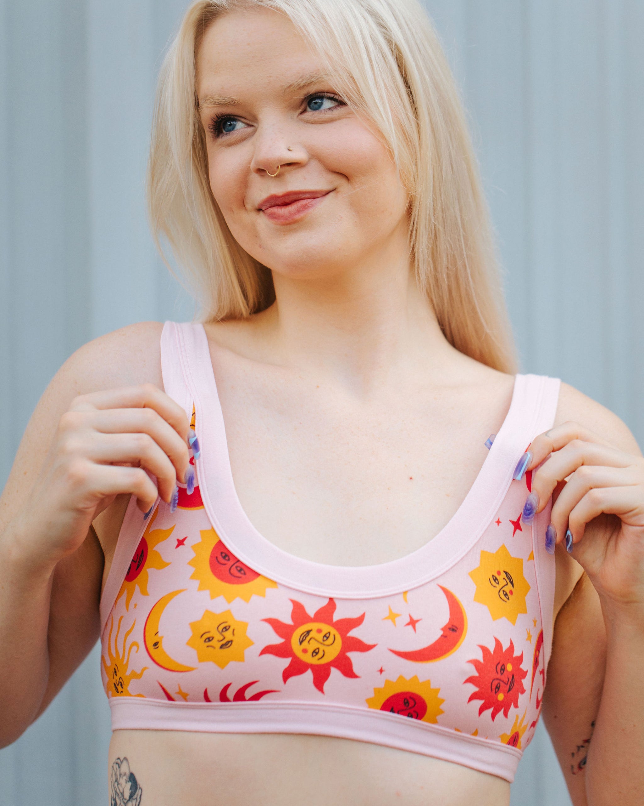 Model wearing Thunderpants Bralette in Luna y Sol print - pink, yellow, and orange suns and moons.