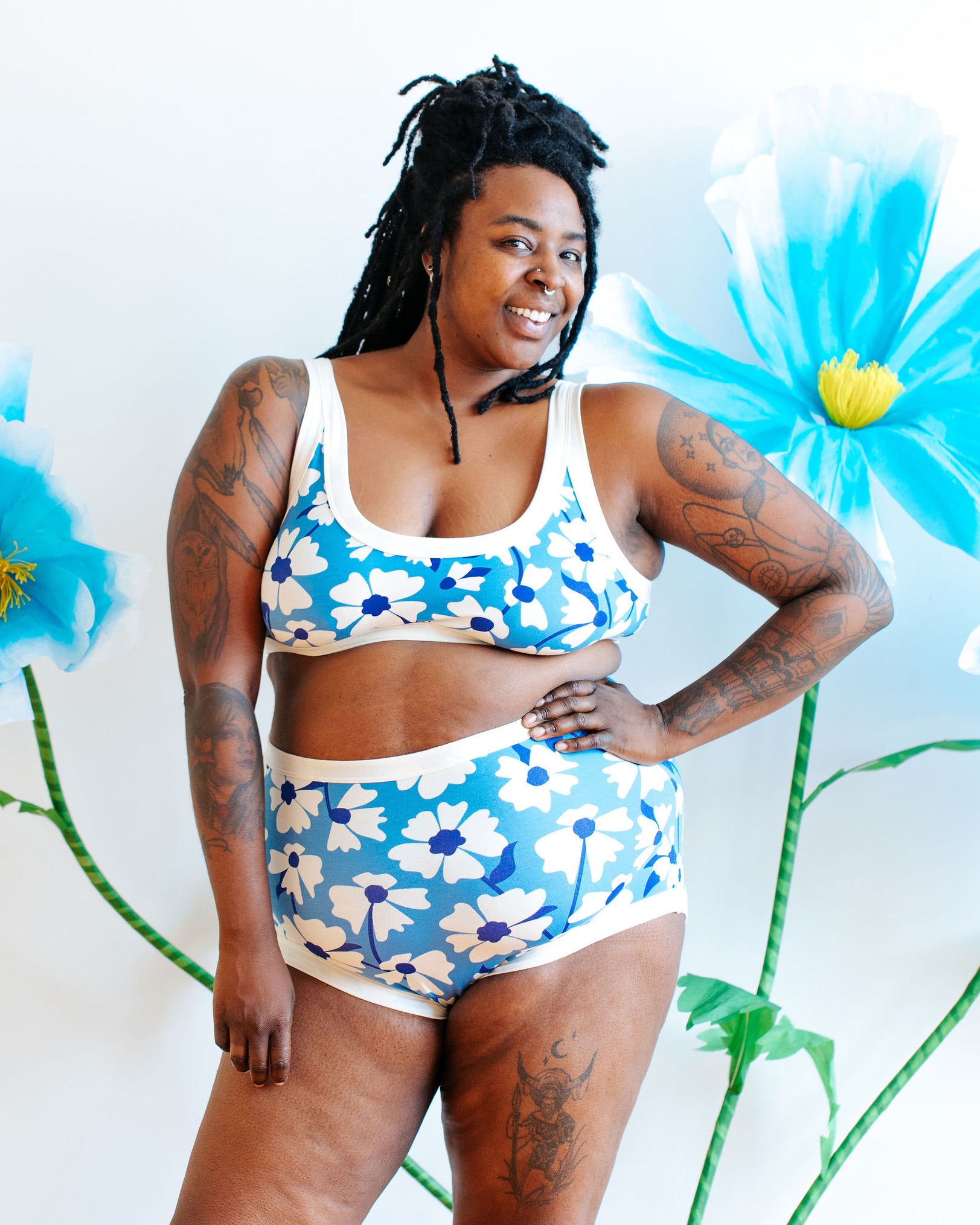 Model wearing Thunderpants Bralette and Sky Rise style in Moody Blooms - white and blue flowers with blue background.