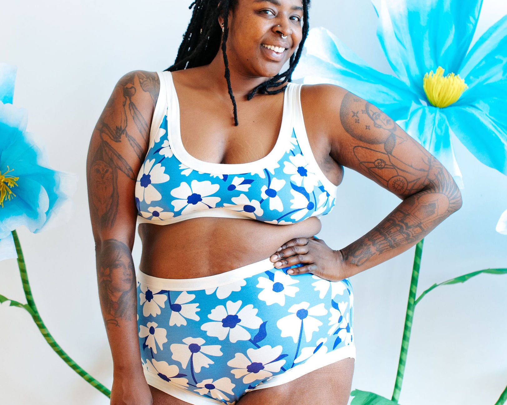 Model wearing Thunderpants Bralette and Sky Rise style in Moody Blooms - white and blue flowers with blue background.
