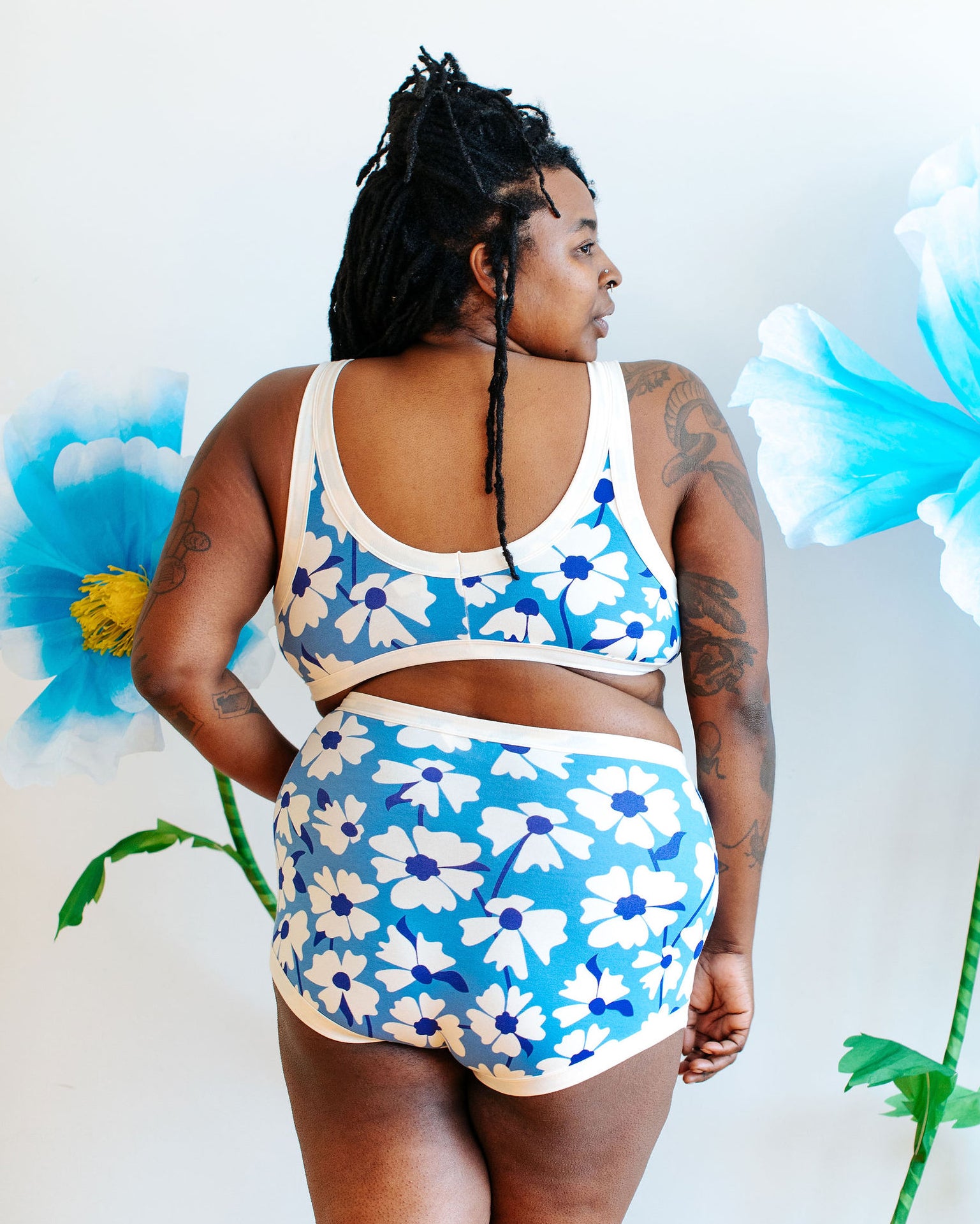 Model wearing Thunderpants Bralette and Sky Rise style in Moody Blooms - white and blue flowers with blue background.