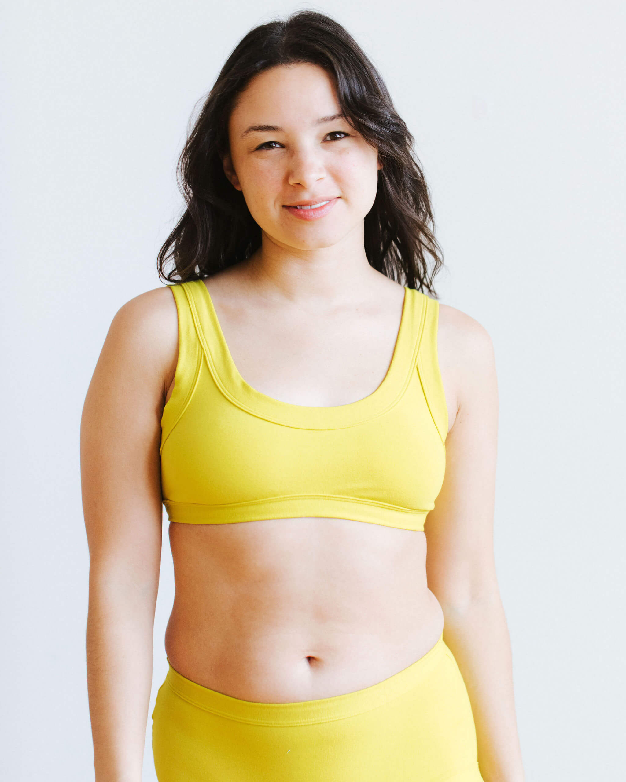 Model wearing Thunderpants Bralette in Star Fruit color - a chartreuse yellow.